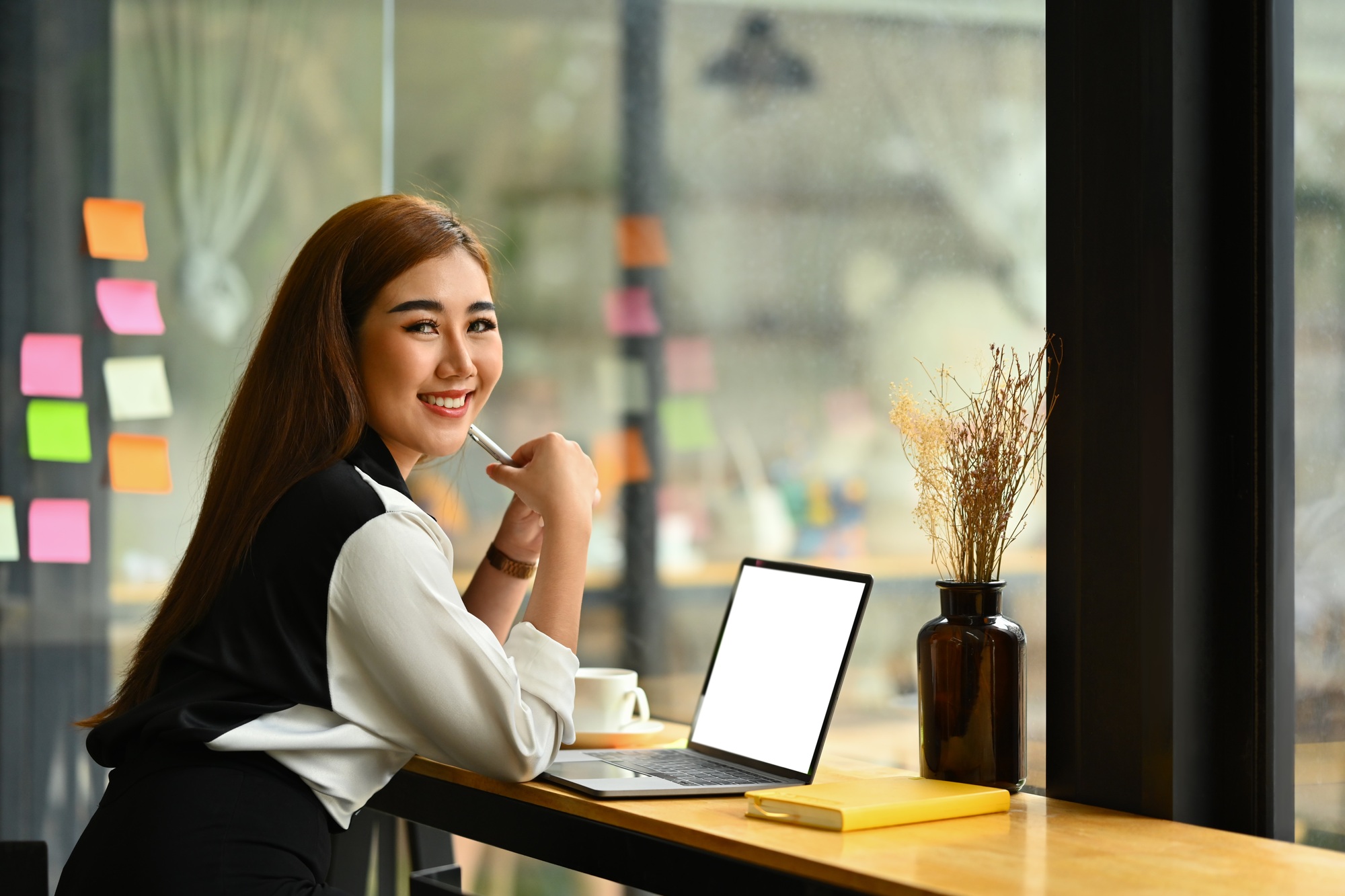Image of successful startup business founder sitting in modern office with laptop.