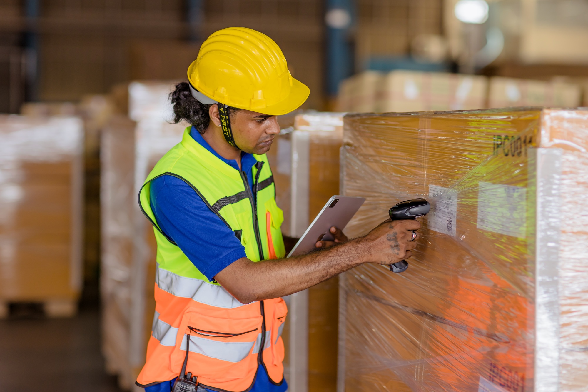 indian worker in logistics industry working inventory management system using barcode reader