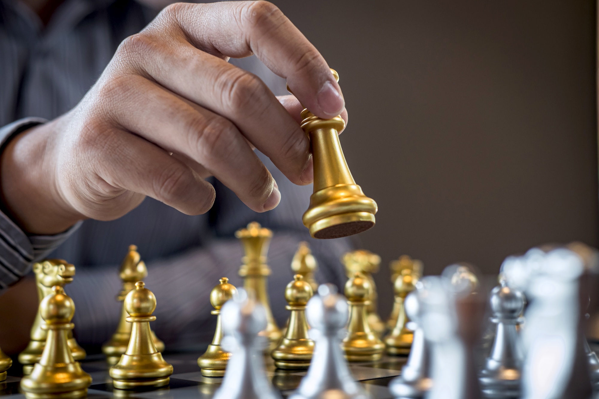 Intelligent businessman playing chess game competition to planning business strategic to development