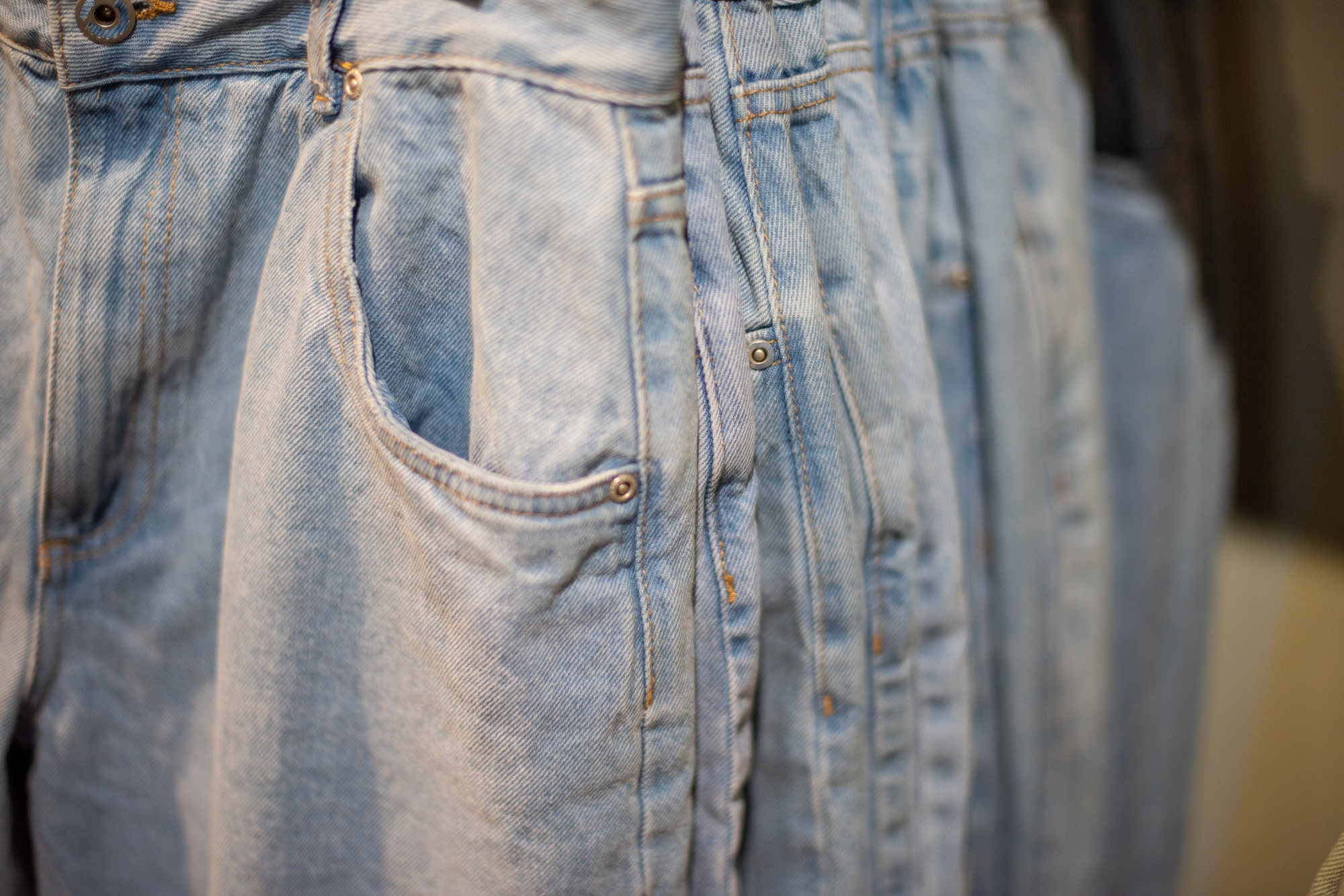 Jeans hanging on rack at retail store