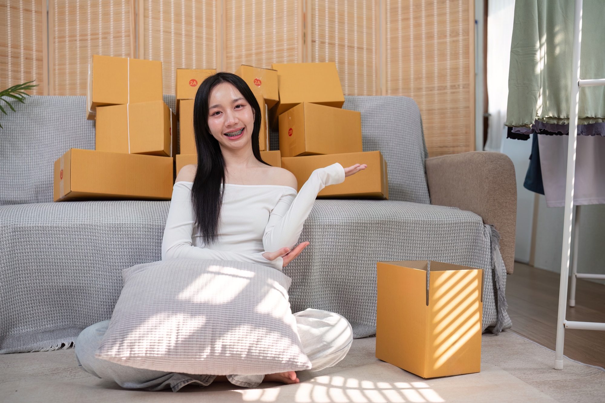 Joyful young female entrepreneur showcasing her ecommerce shipping process
