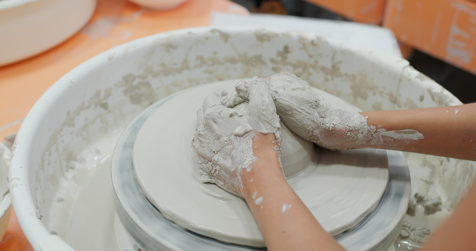 Making ceramic pot on turning pottery wheel