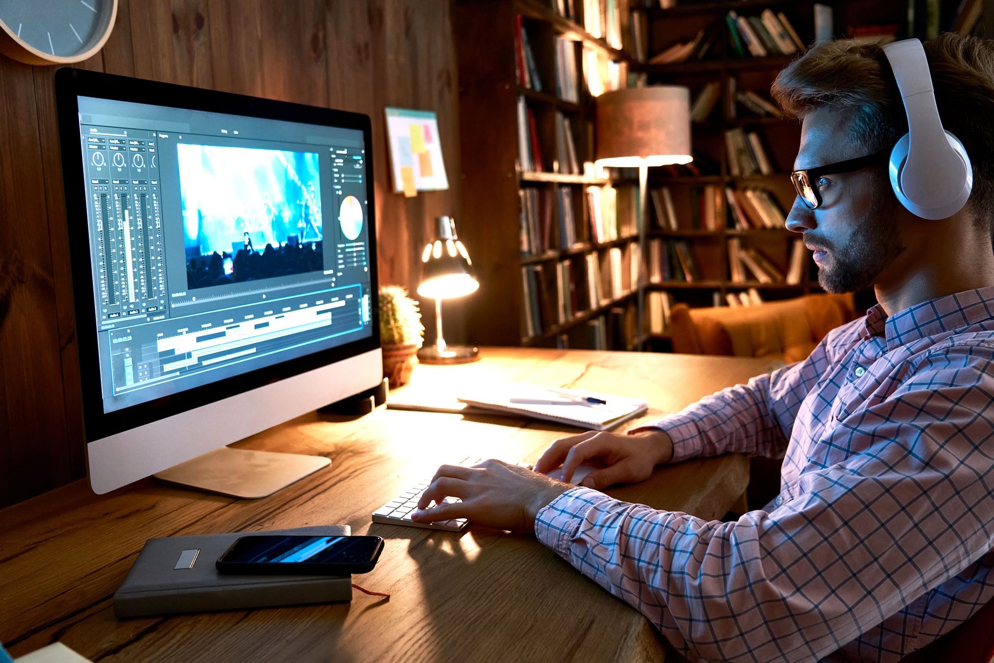 Male videographer editor using pc computer editing footage at home office.