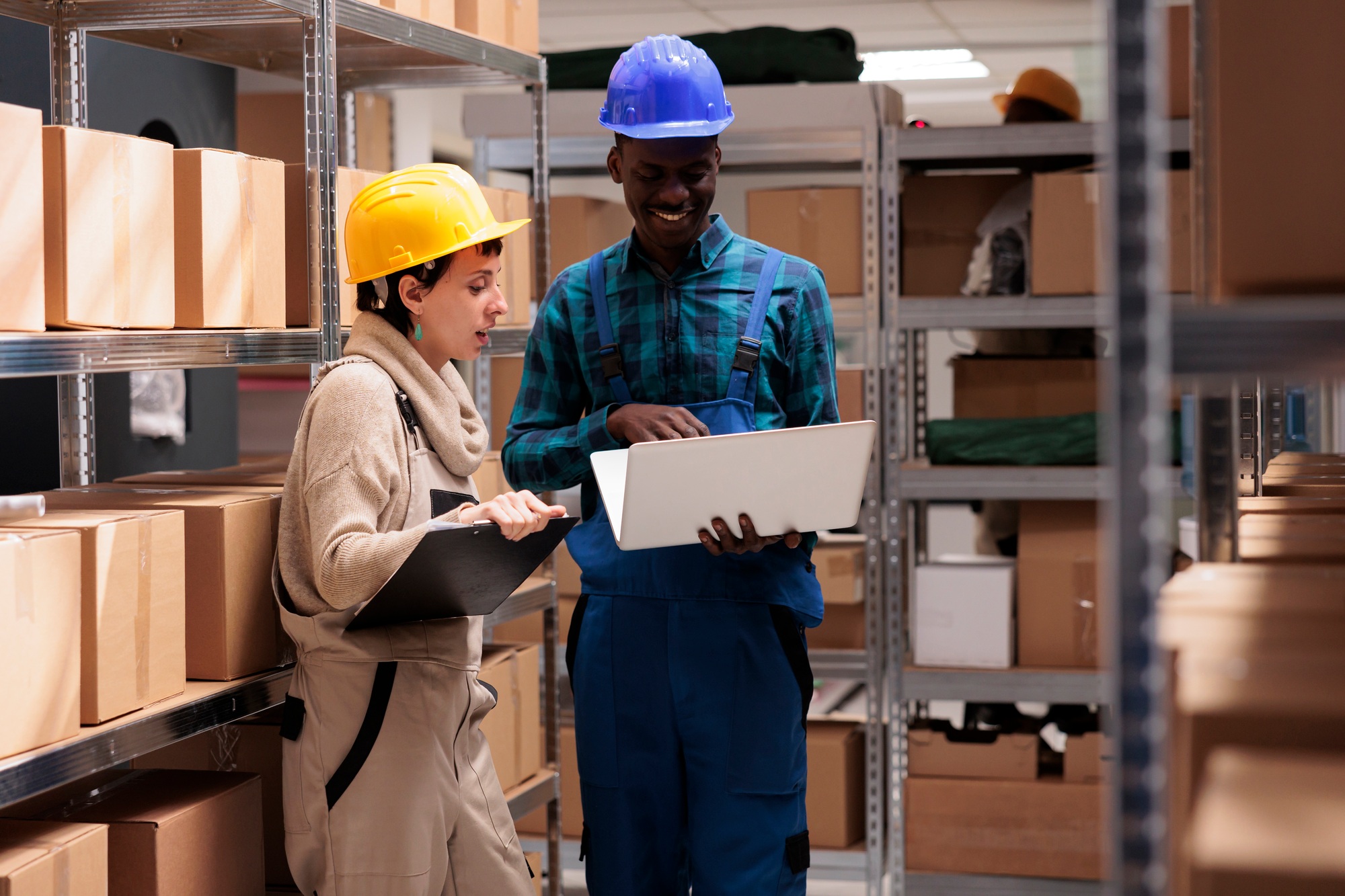 Man and woman warehouse coworkers supervising inventory together