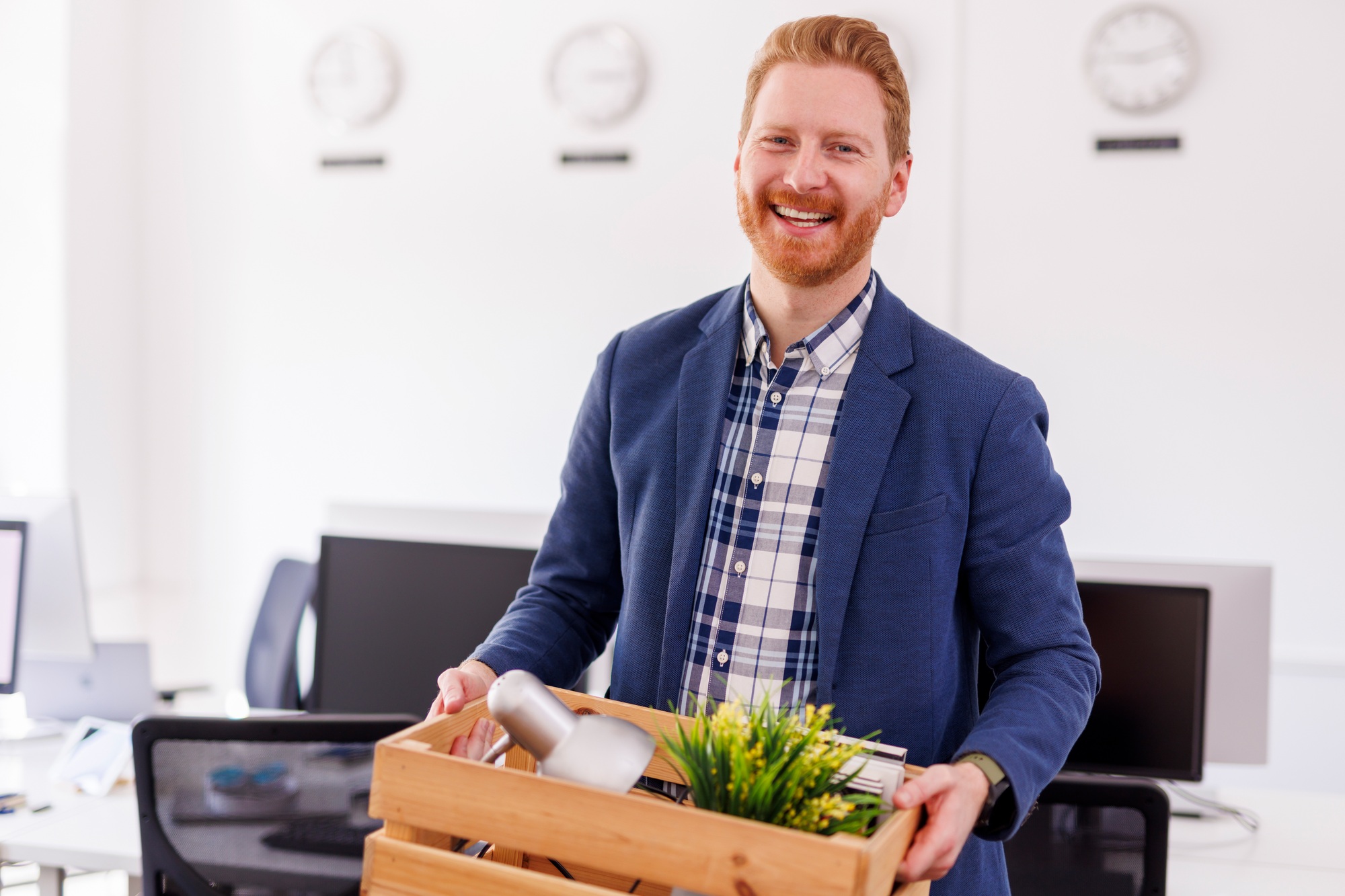 Man hired to new job carrying things in box while moving in new office