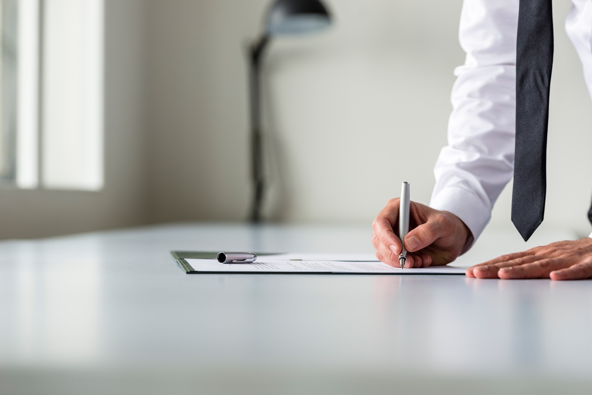Man in white shirt signing contract or subscription form