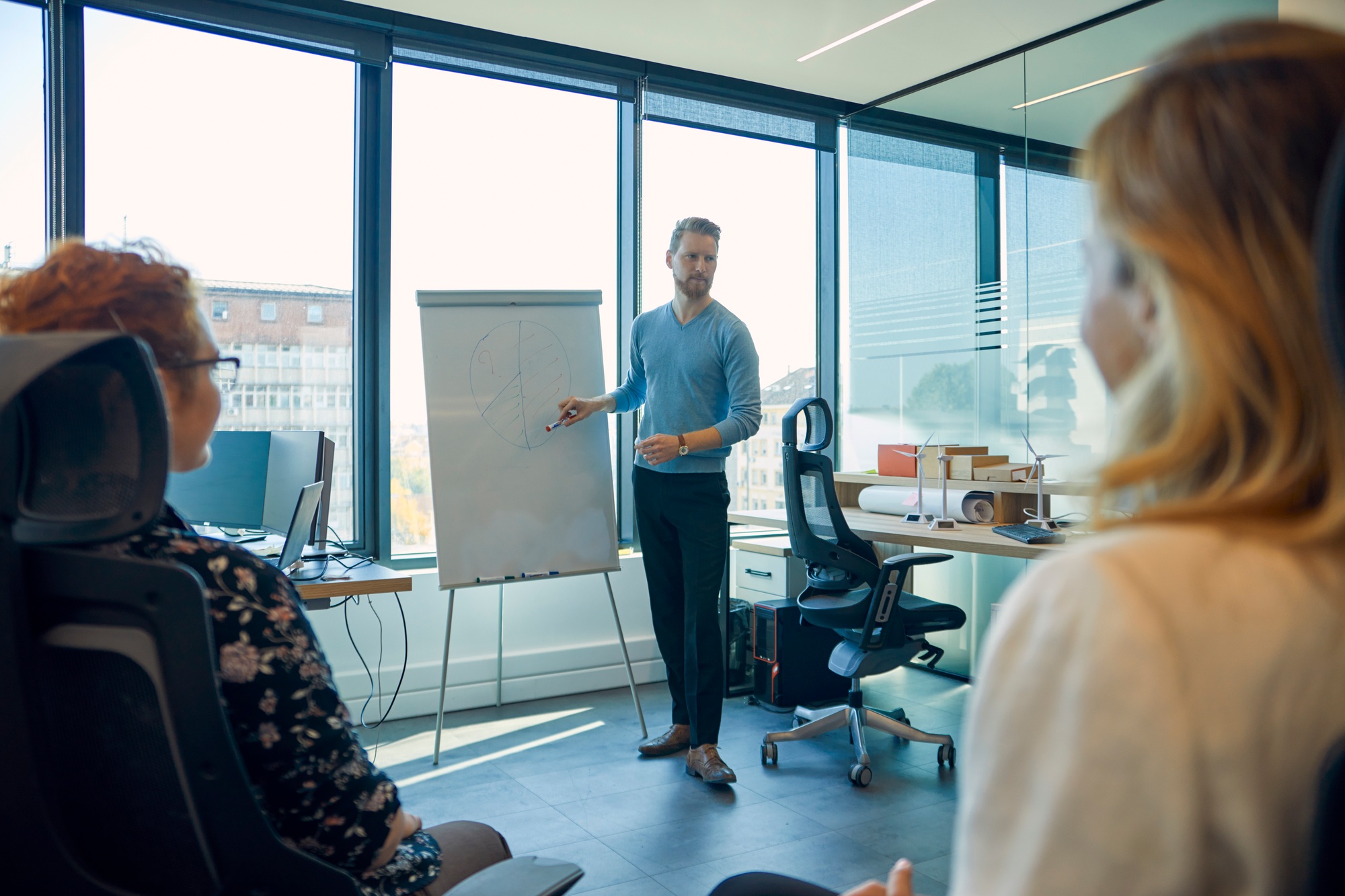 Man leading a presentation at flip chart in office