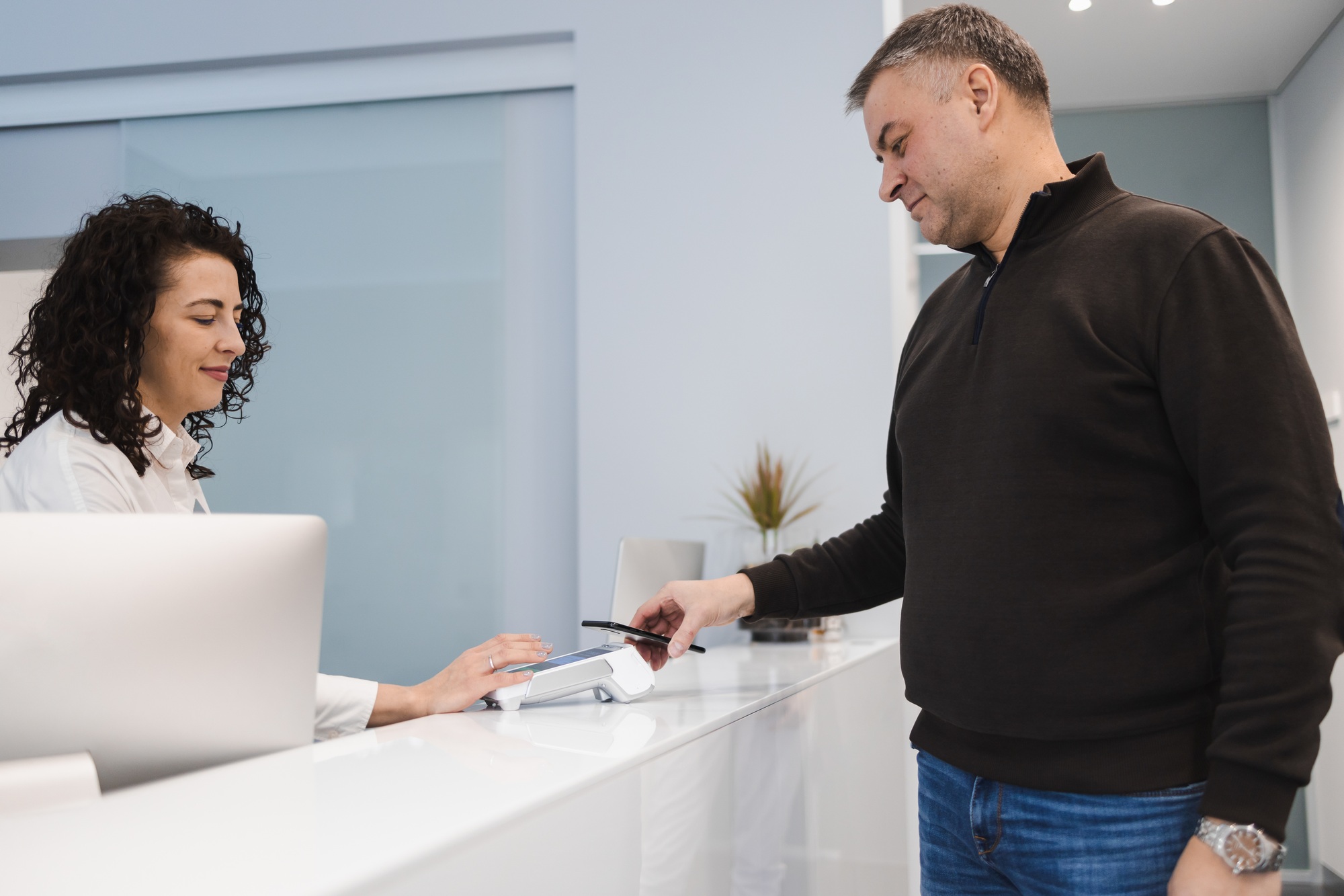 Man pays for services using a smartphone with nfc in a pos terminal