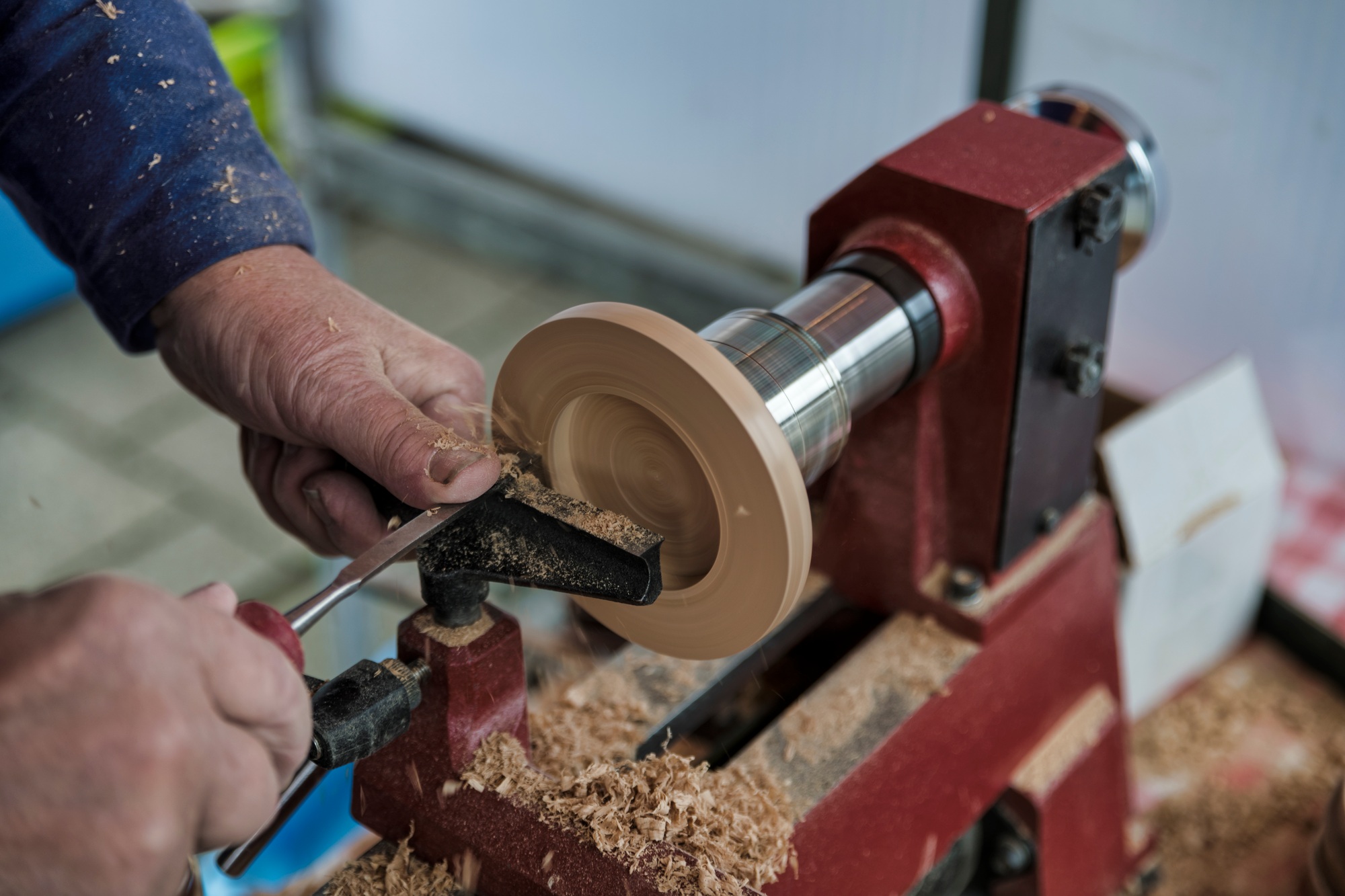 man turning wooden candle stands on a wood lathe