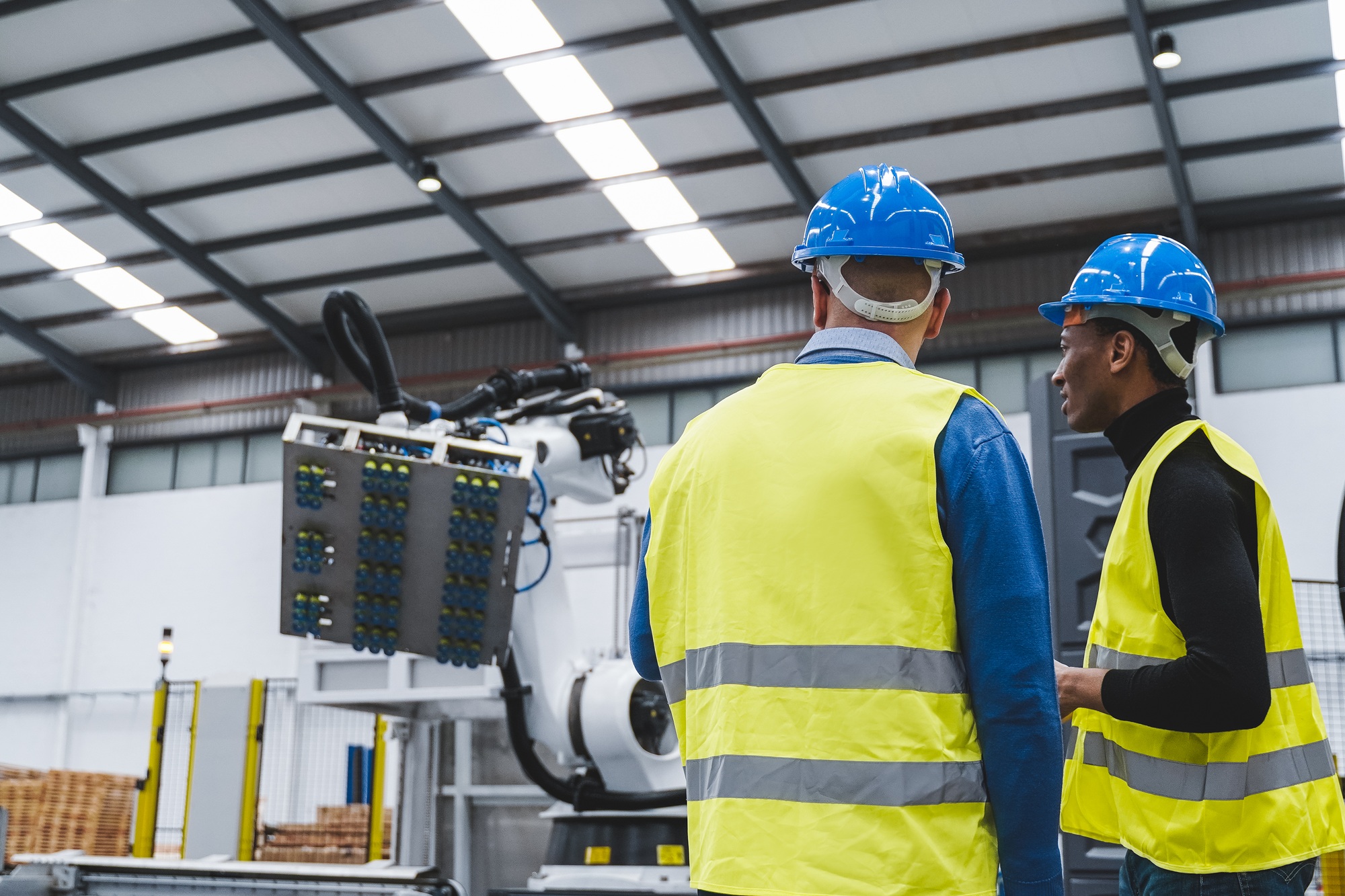 Multiracial engineers working inside automation and robotics facility - New industrial tech concept