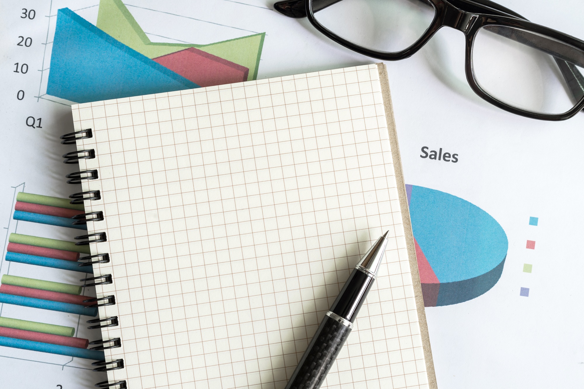 Notebook with paper graph analysis on office desk