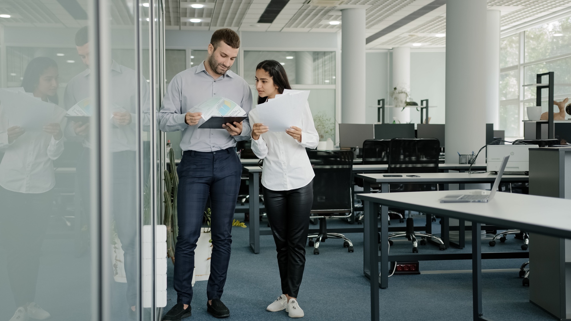 Office colleagues communicate at workplace compare report discuss new strategic business plan talk