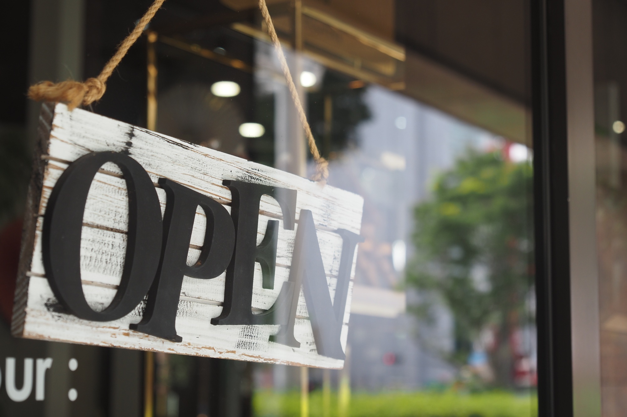 Open sign displayed at a storefront welcoming customers