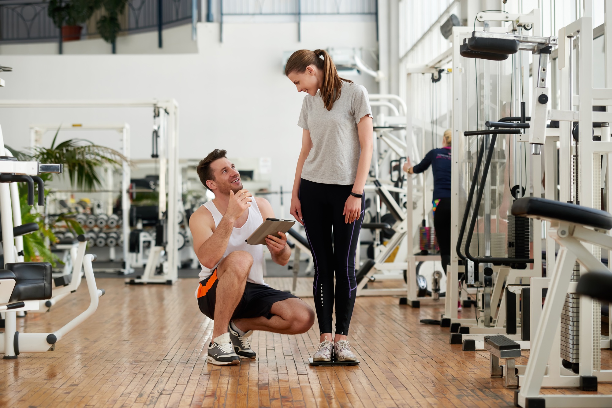 Personal trainer and woman checking her progress