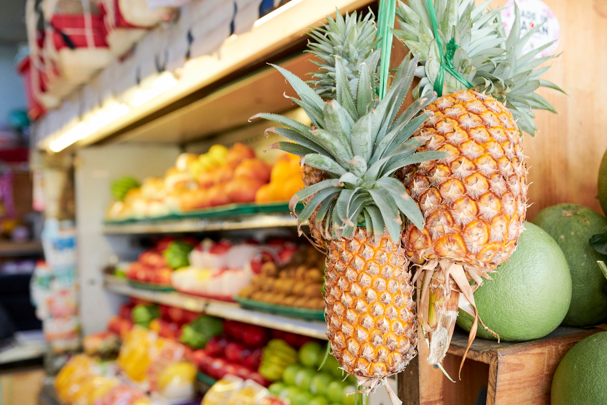 Pineapples handing on store display