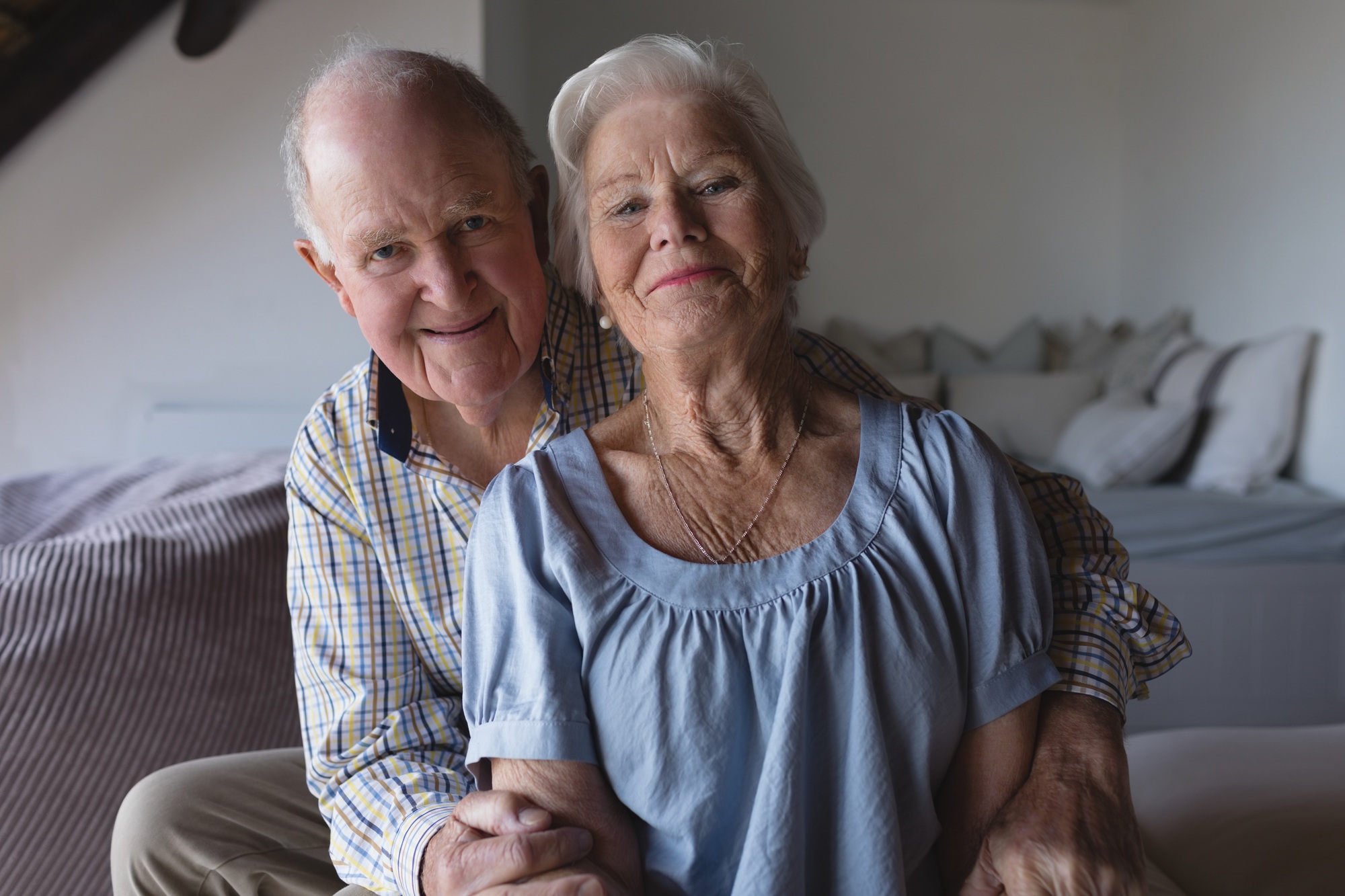 Portrait of a senior couple sitting together and looking at the goal in living room at home