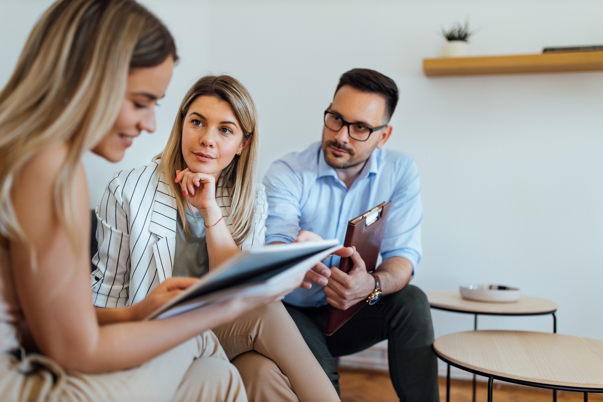 Portrait of a two managers talking to a younger employee.