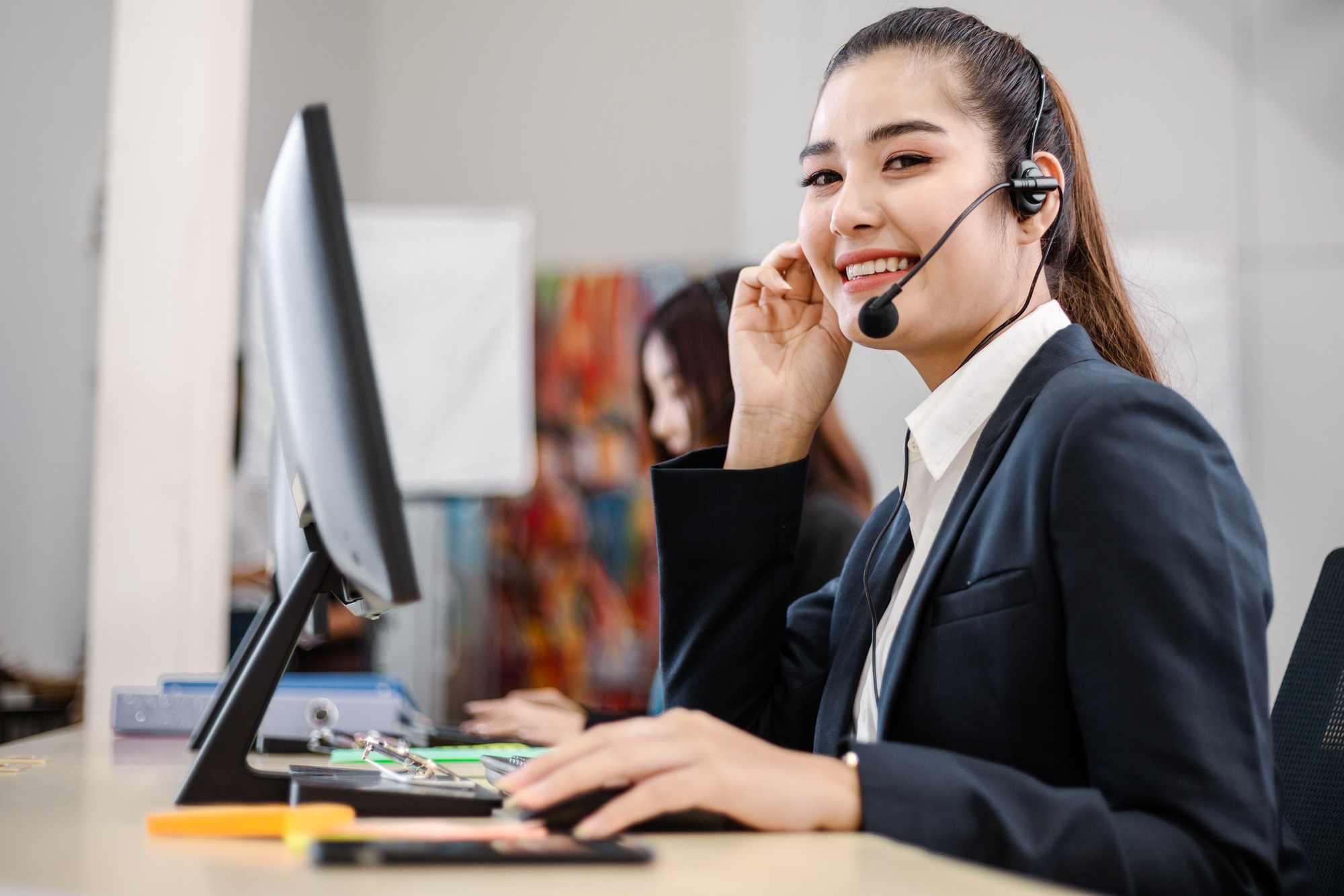 Portrait of cheerful Asian woman staff at customer support center