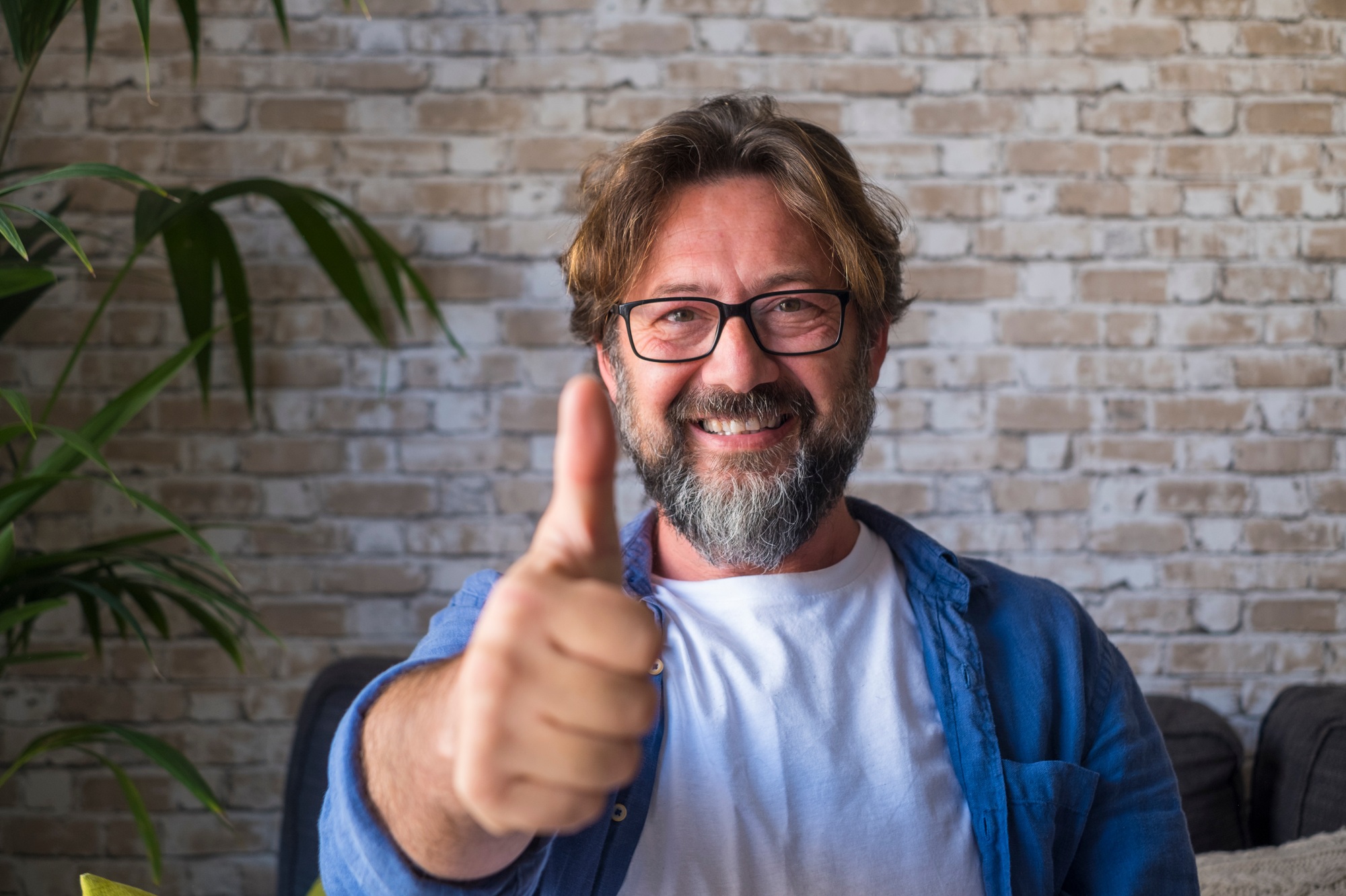 Portrait of cheerful mature man in eyeglasses giving approval or appreciations sign by gesturing