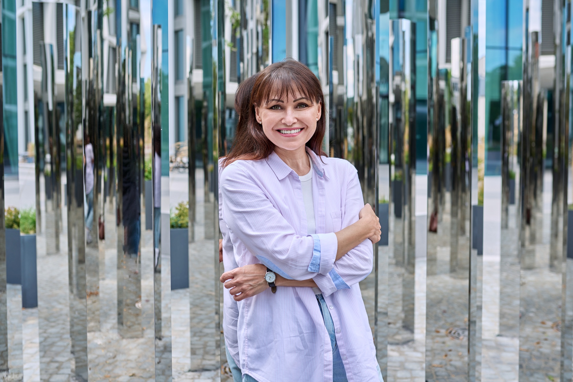 Portrait of confident mature woman on mirror urban background
