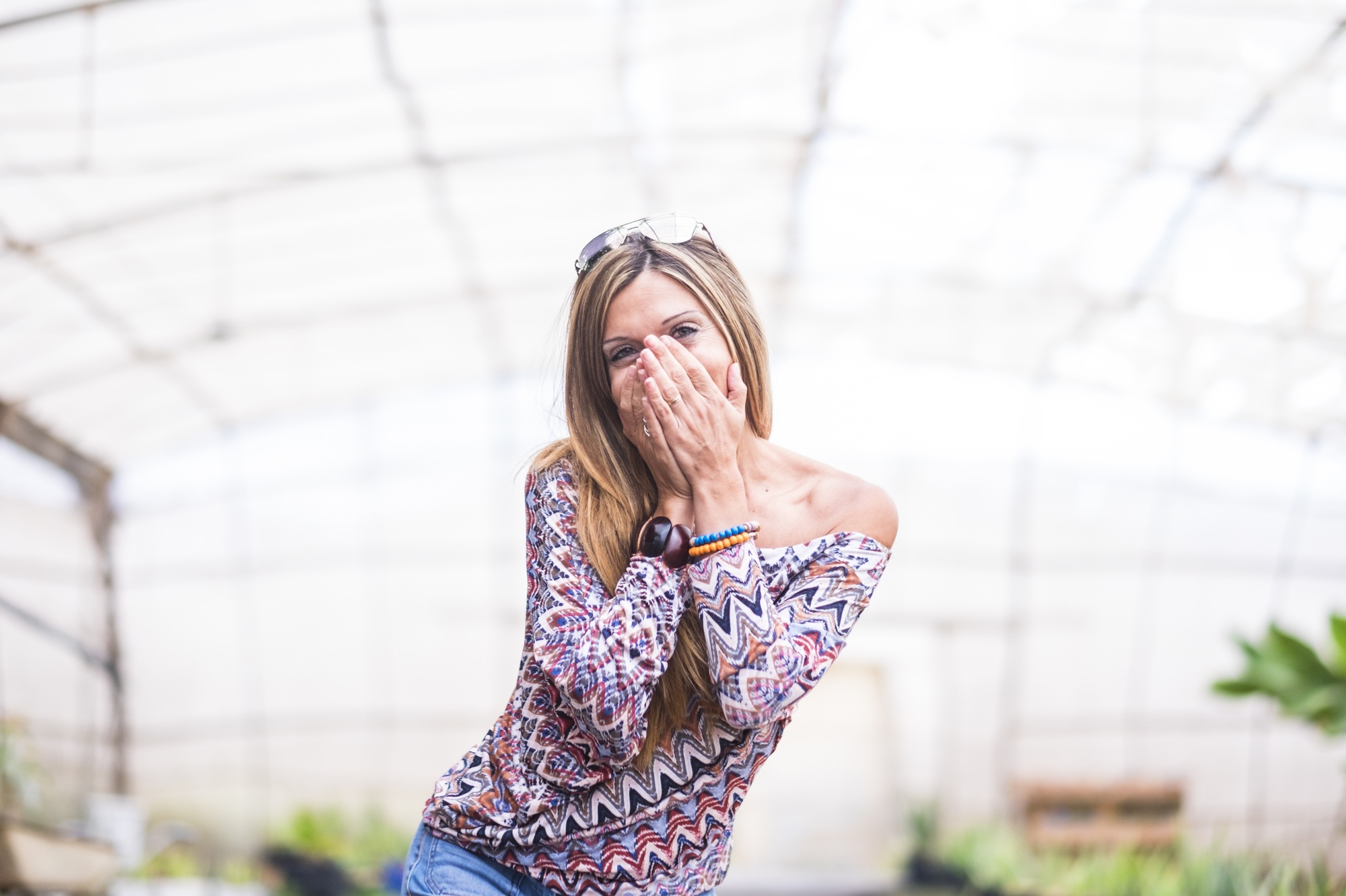 Portrait of excited beautiful woman covering her mouth with hands trying to stop giggling