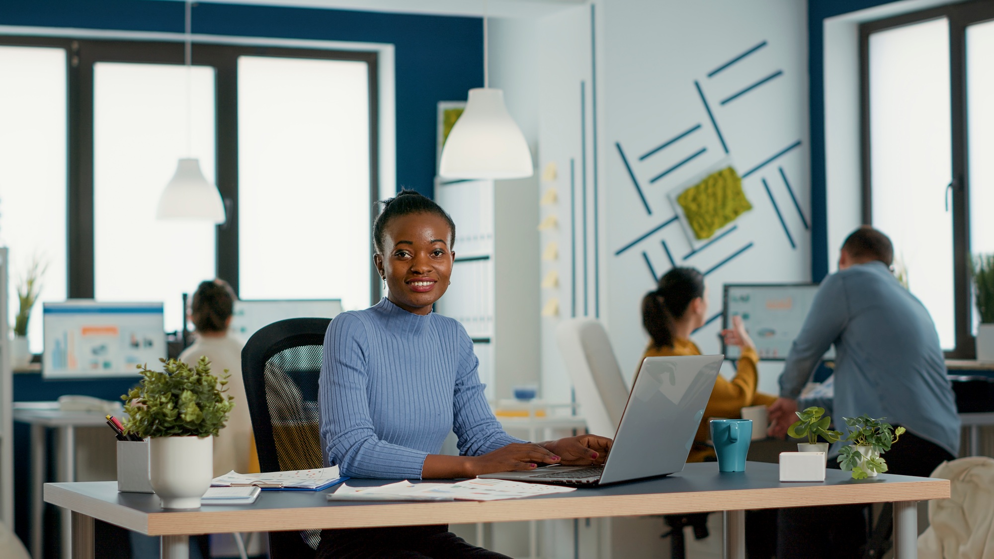 Portrait of smiling african american woman working on profit margin and sale statistics using laptop