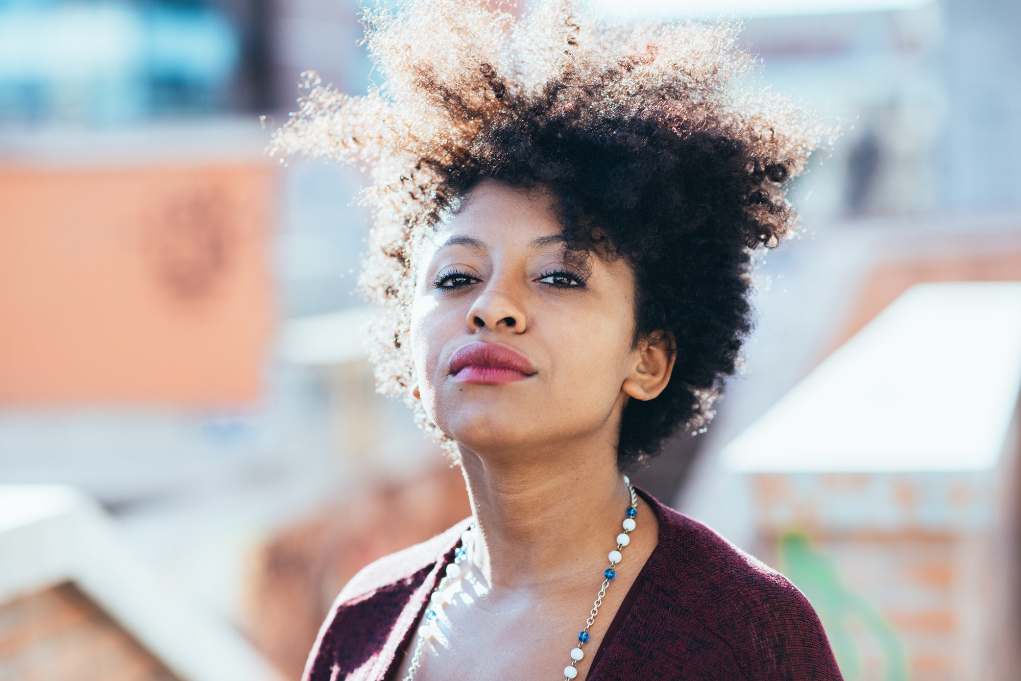 Portrait of young beautiful afro black woman looking at camera resolute