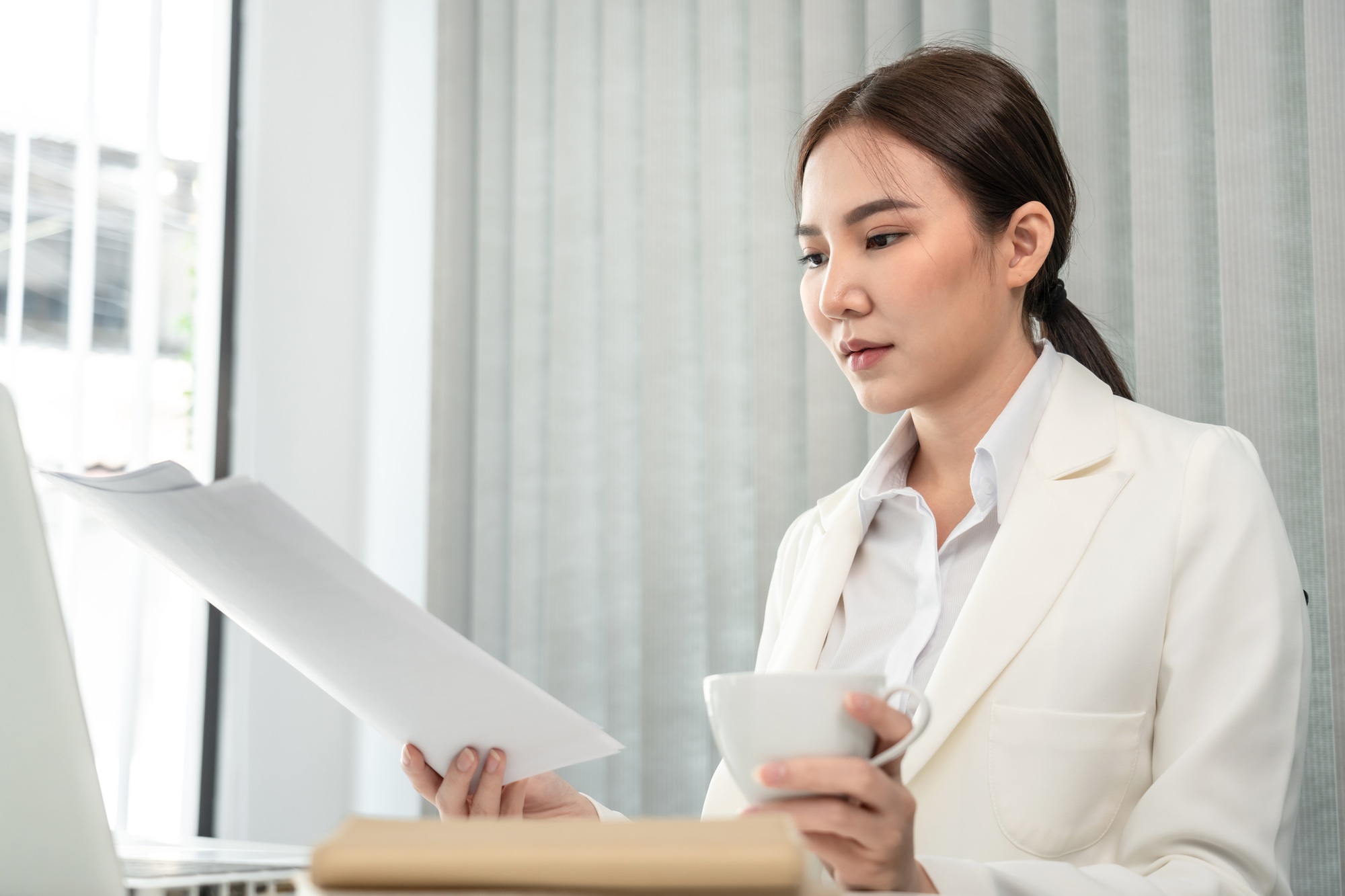 Professional businesswoman analyzing graph data from document in hand, Market research reports