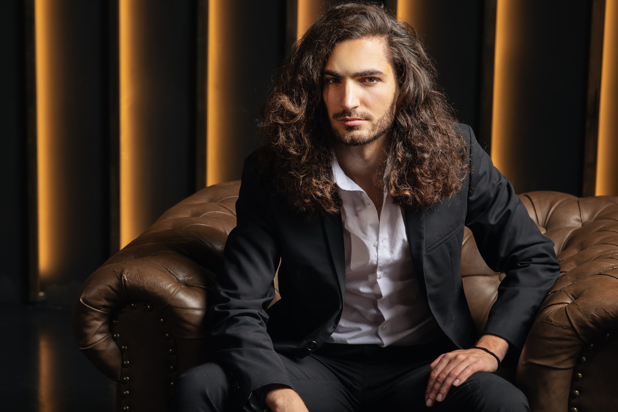 Professional young man poses confidently in stylish office setting