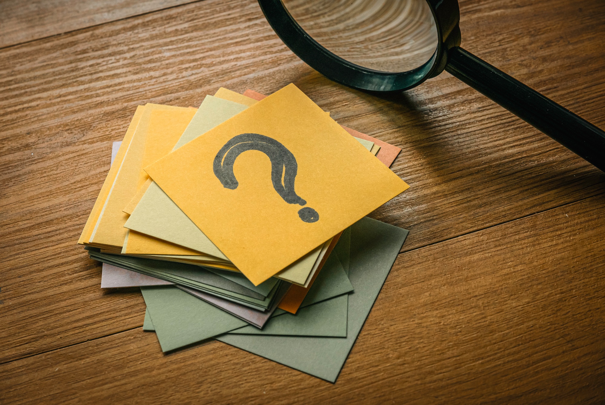 Questions and answers concept. A stack of paper with a paper on top written with question symbol tog
