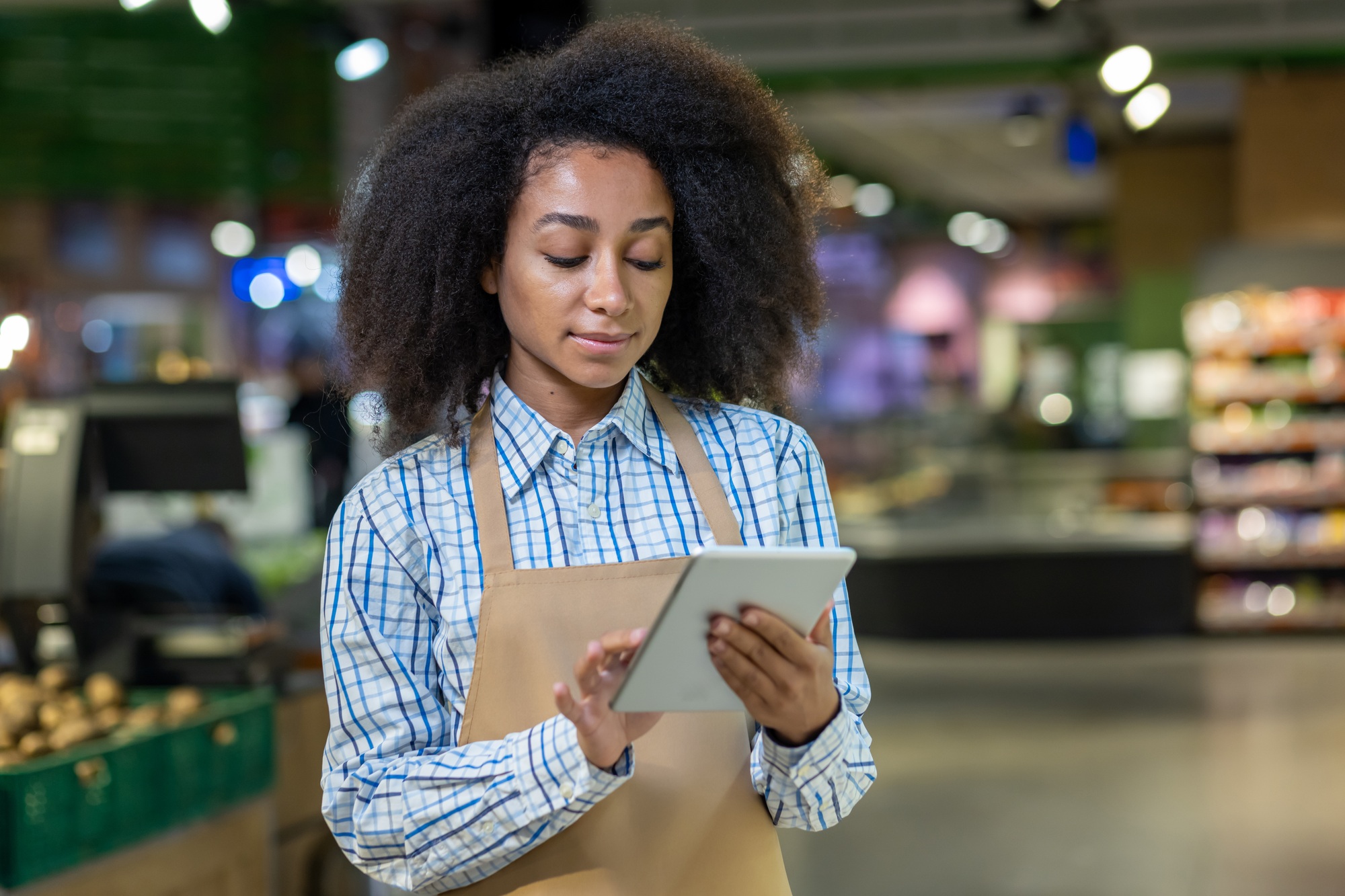 Retail worker using digital tablet in supermarket for inventory management