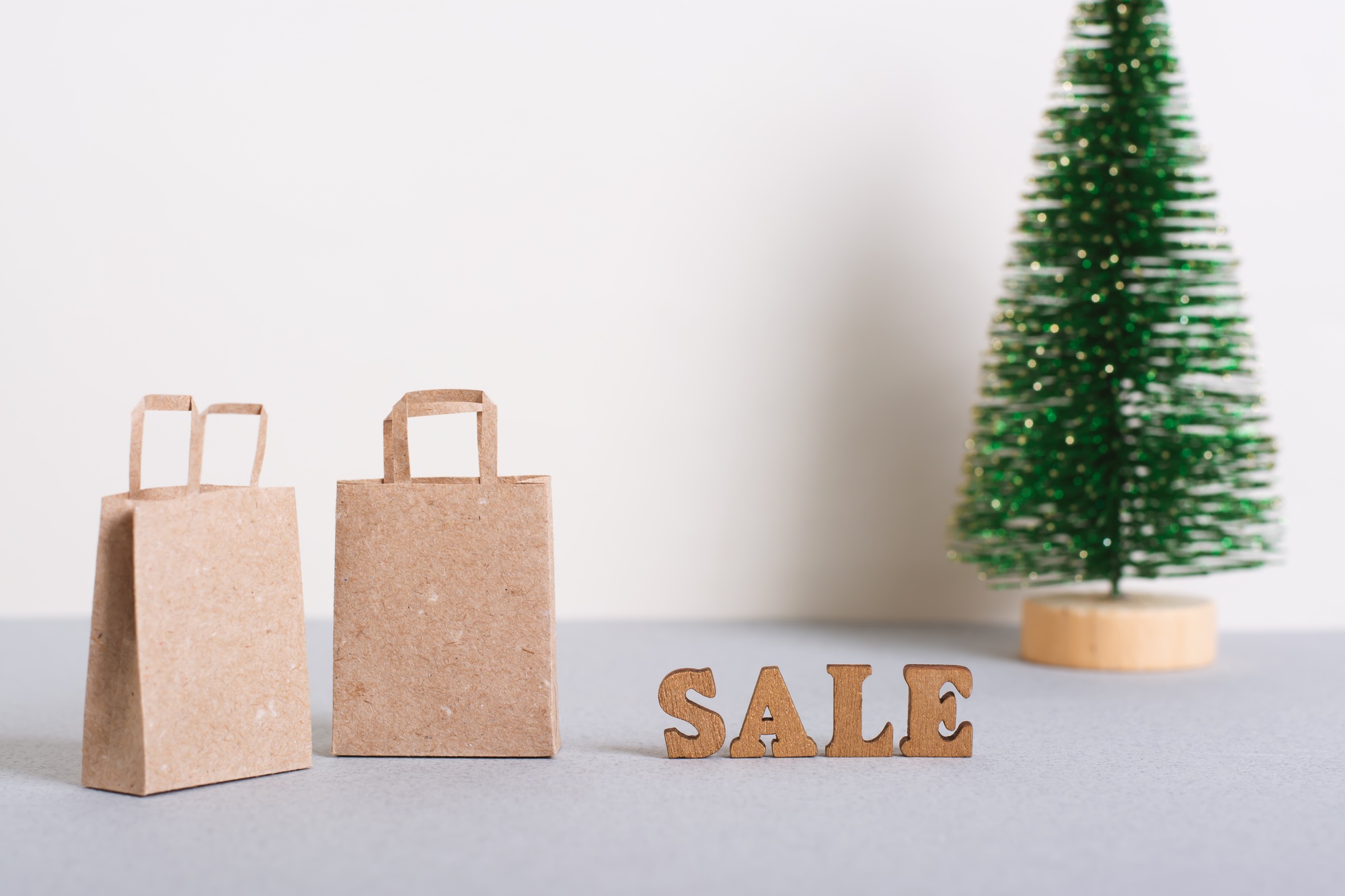 Sale before christmas inscription and paper craft bags on the table