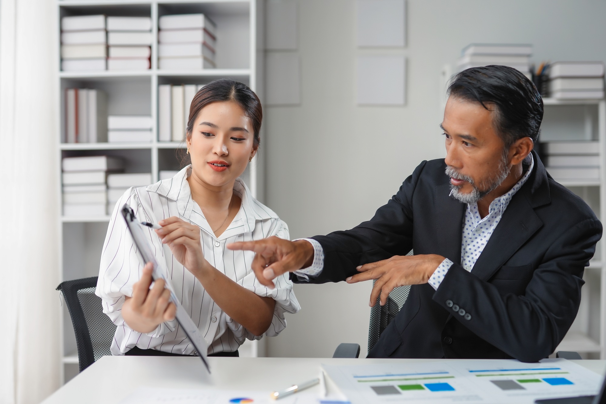 Senior executive and a junior staff member are reviewing business strategies