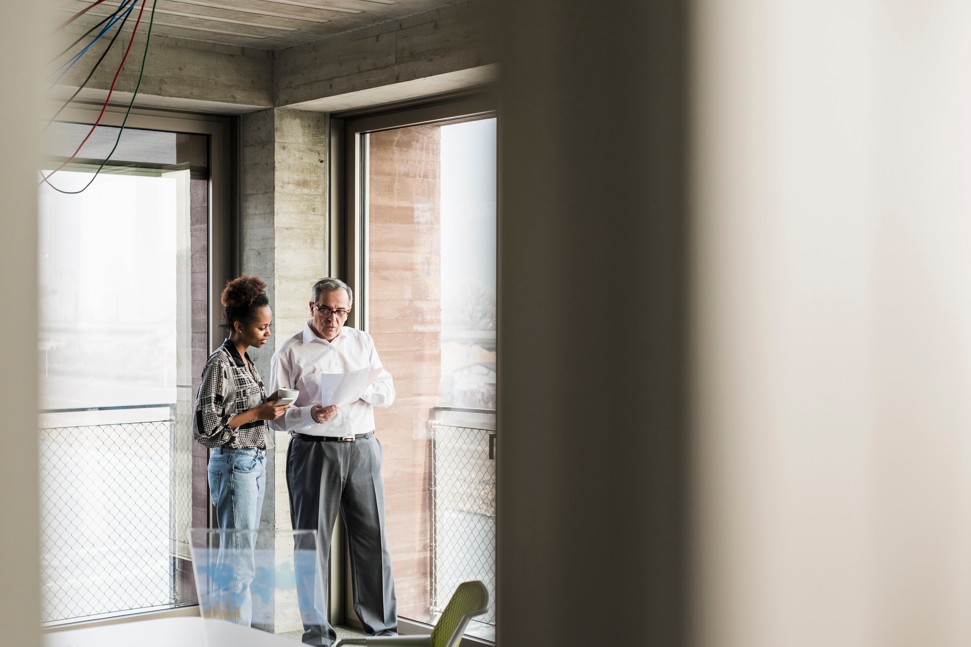 Senior manager discussing documents with young coworker