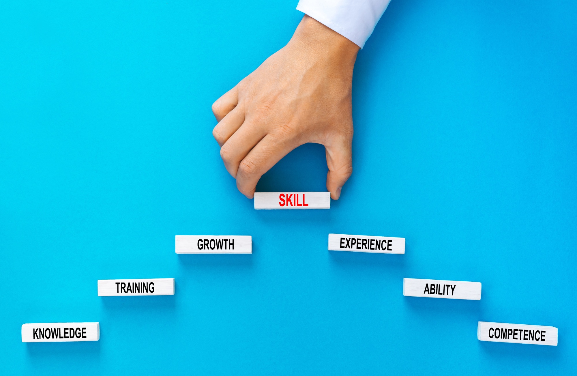 Skill concept. Businessman holding wooden blocks stacking as step stair with skill basic links  on y