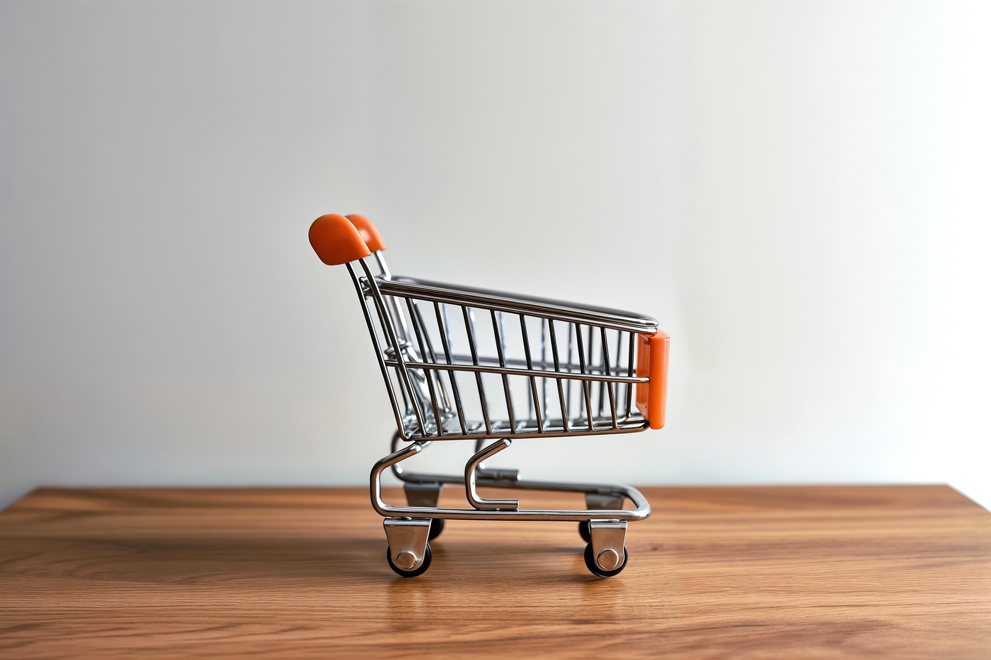 Small shopping cart placed on a wooden table for display
