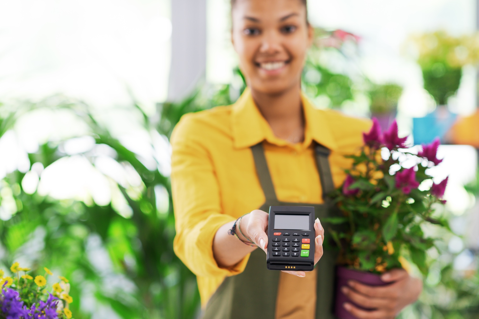 Smiling florist holding a POS terminal