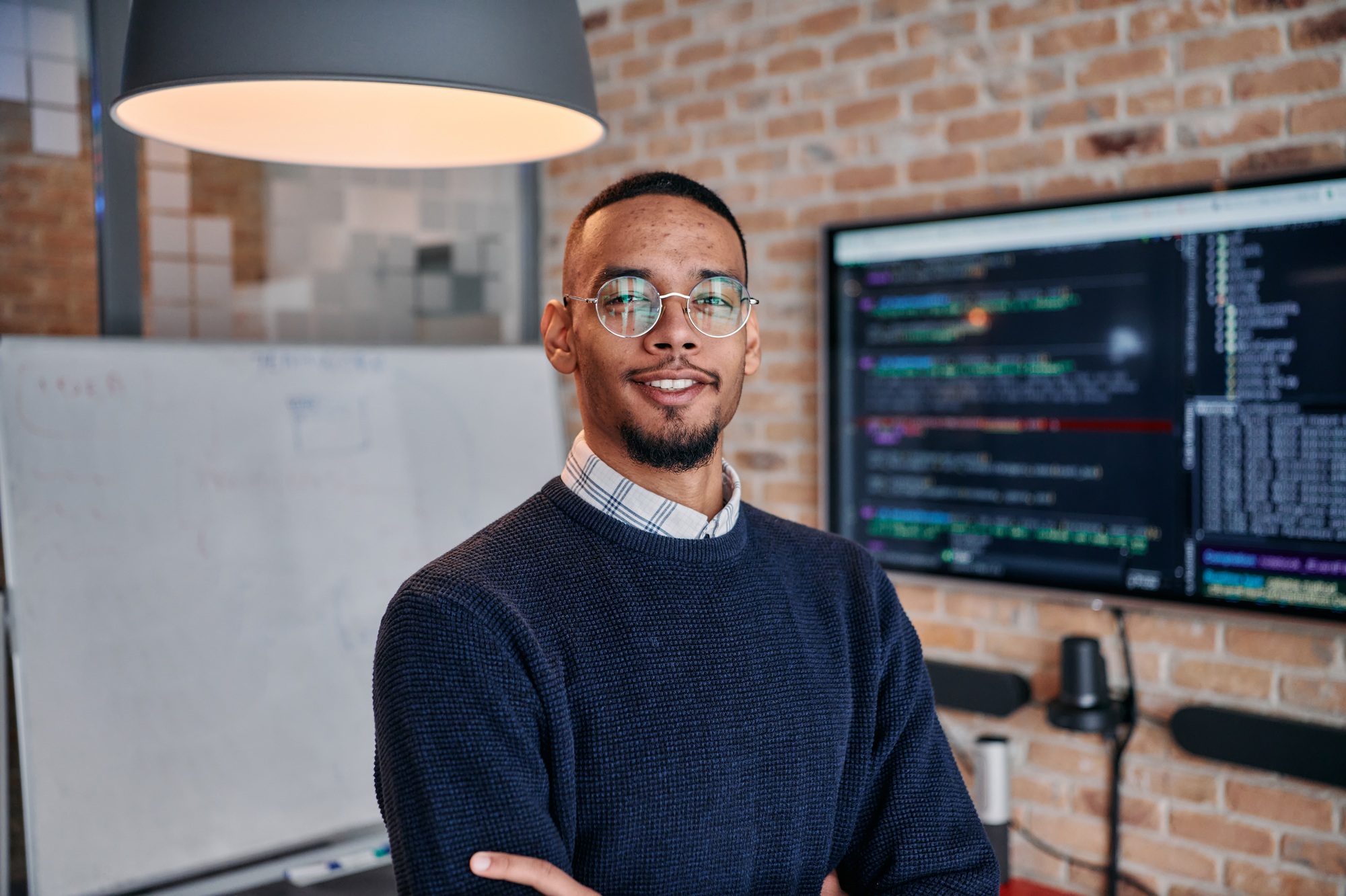 Startup Leadership: African American Businessman in Modern Office with Colleagues in Background.