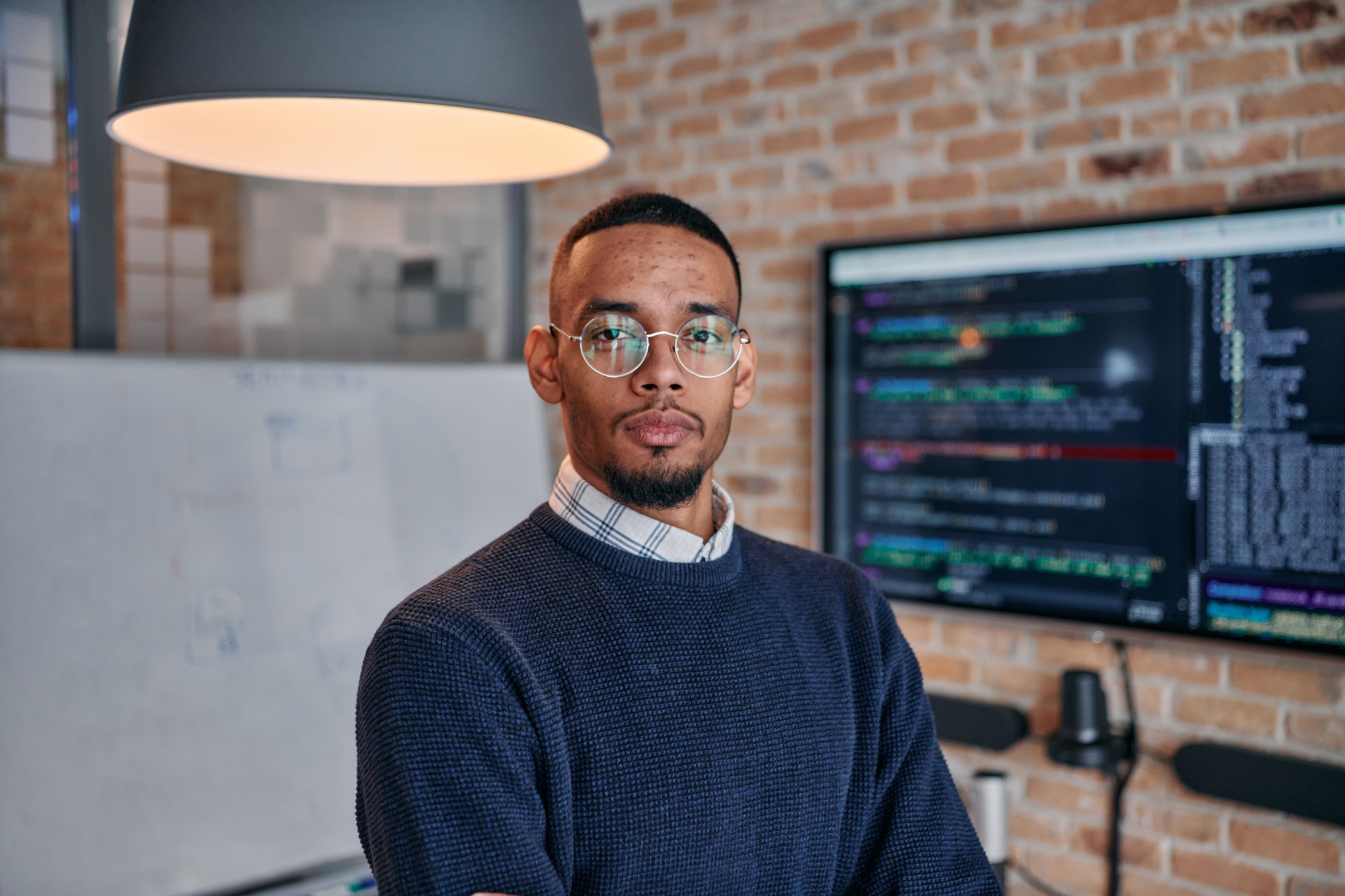 Startup Leadership: African American Businessman in Modern Office with Colleagues in Background.