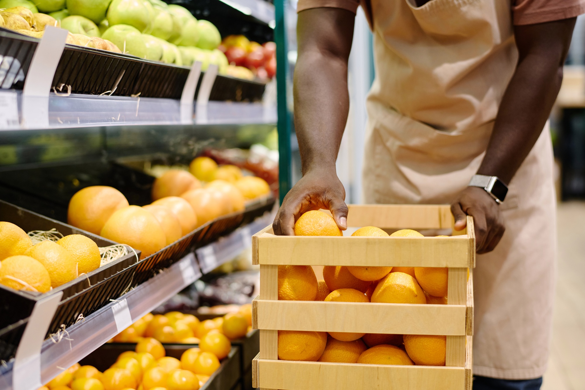 Store employee laying out fruits