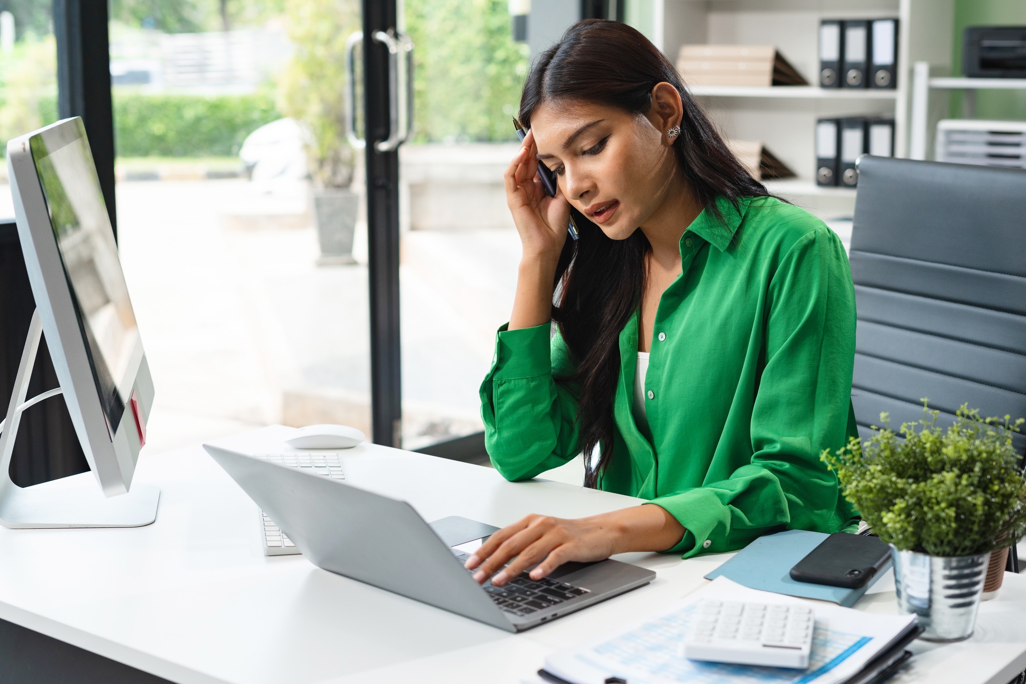 Stressed business woman calculating bills and taxes looking at calculator gesturing