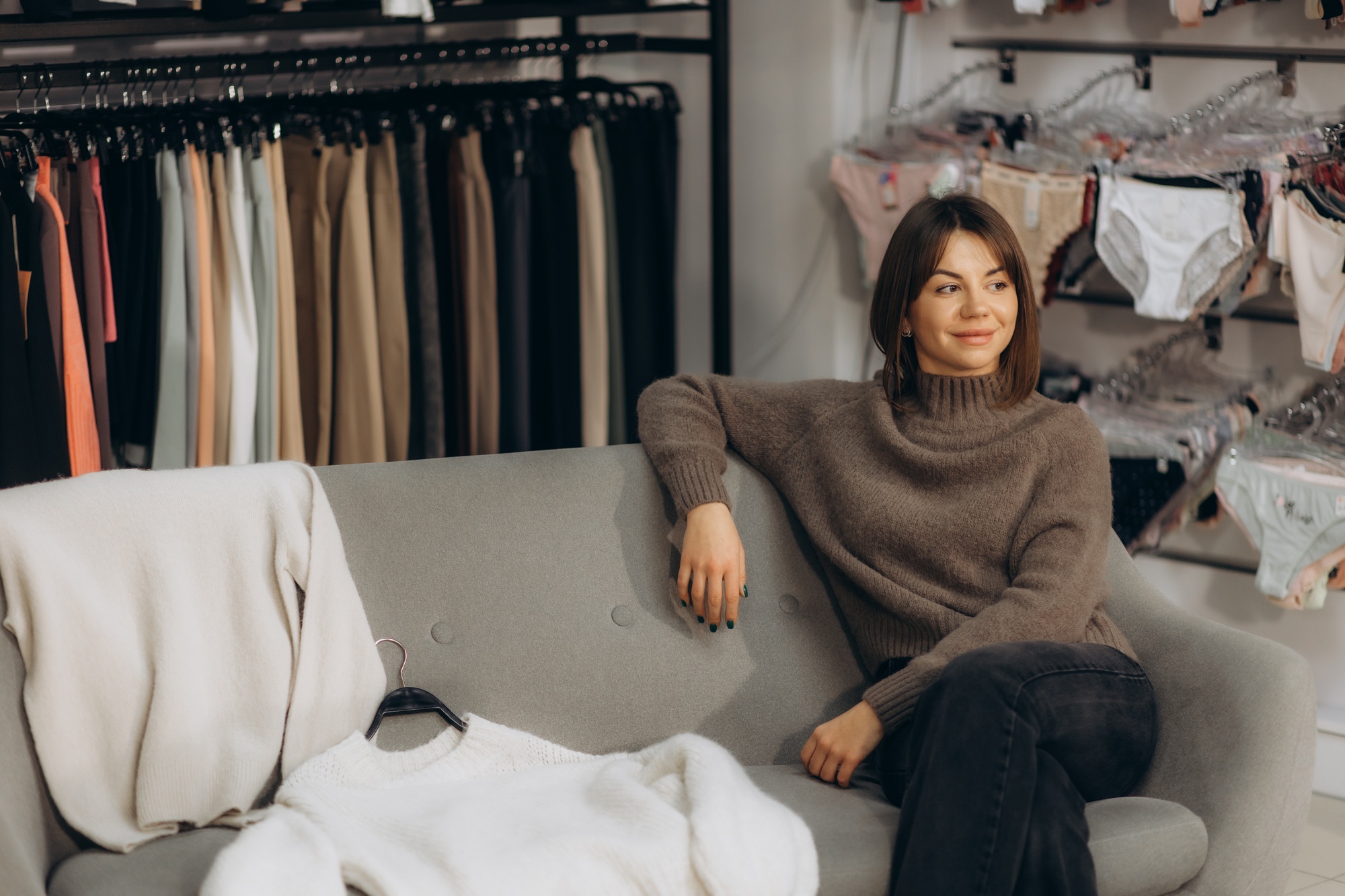 Stylish Woman Relaxing in a Modern Clothing Store on Comfortable Couch