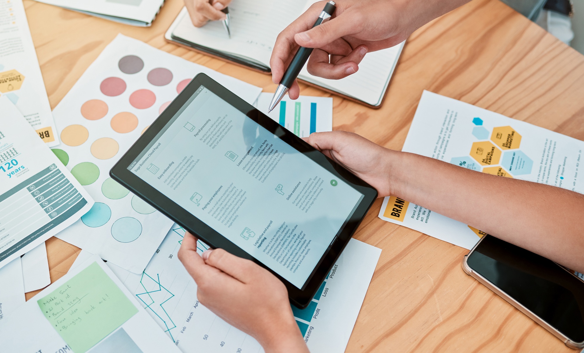 Tablet, paper charts and research for planning, startup company and reading for business process. B