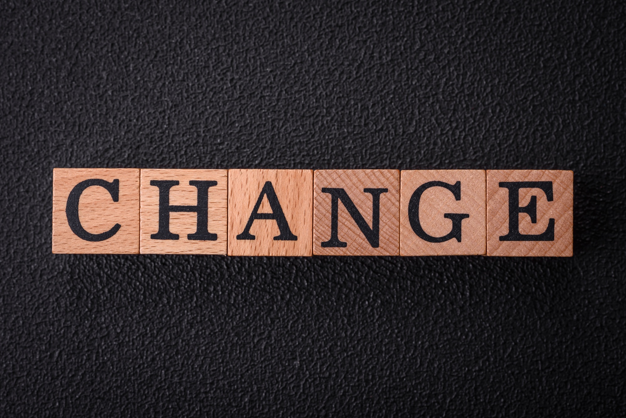 The inscription chance or change with wooden cubes on a dark concrete background