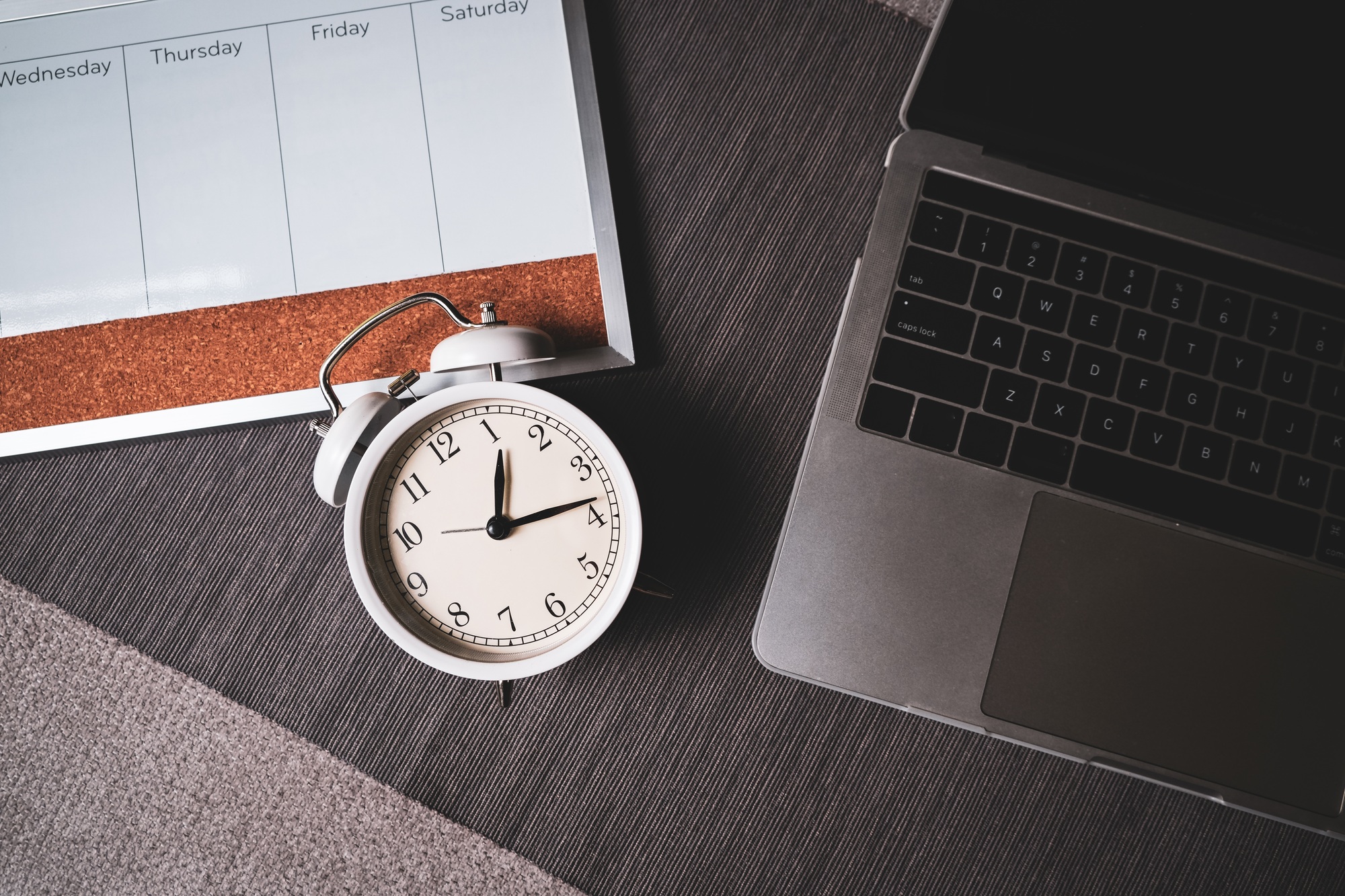 The top view of the clock and computer for time management of work and balance life.