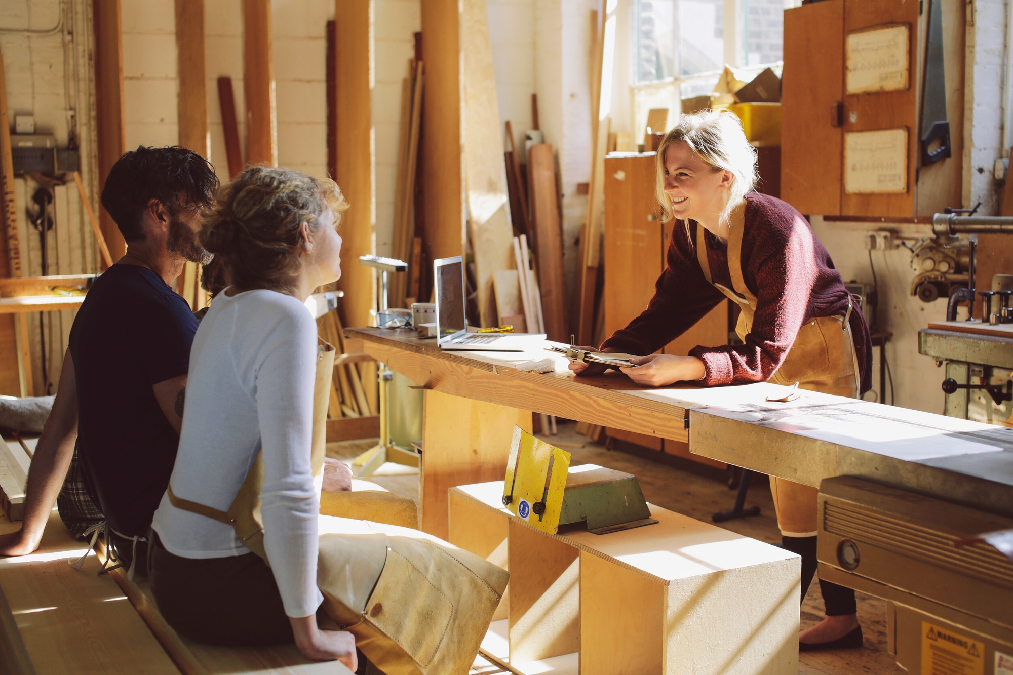 Three craft workers having an informal meeting in pipe organ workshop