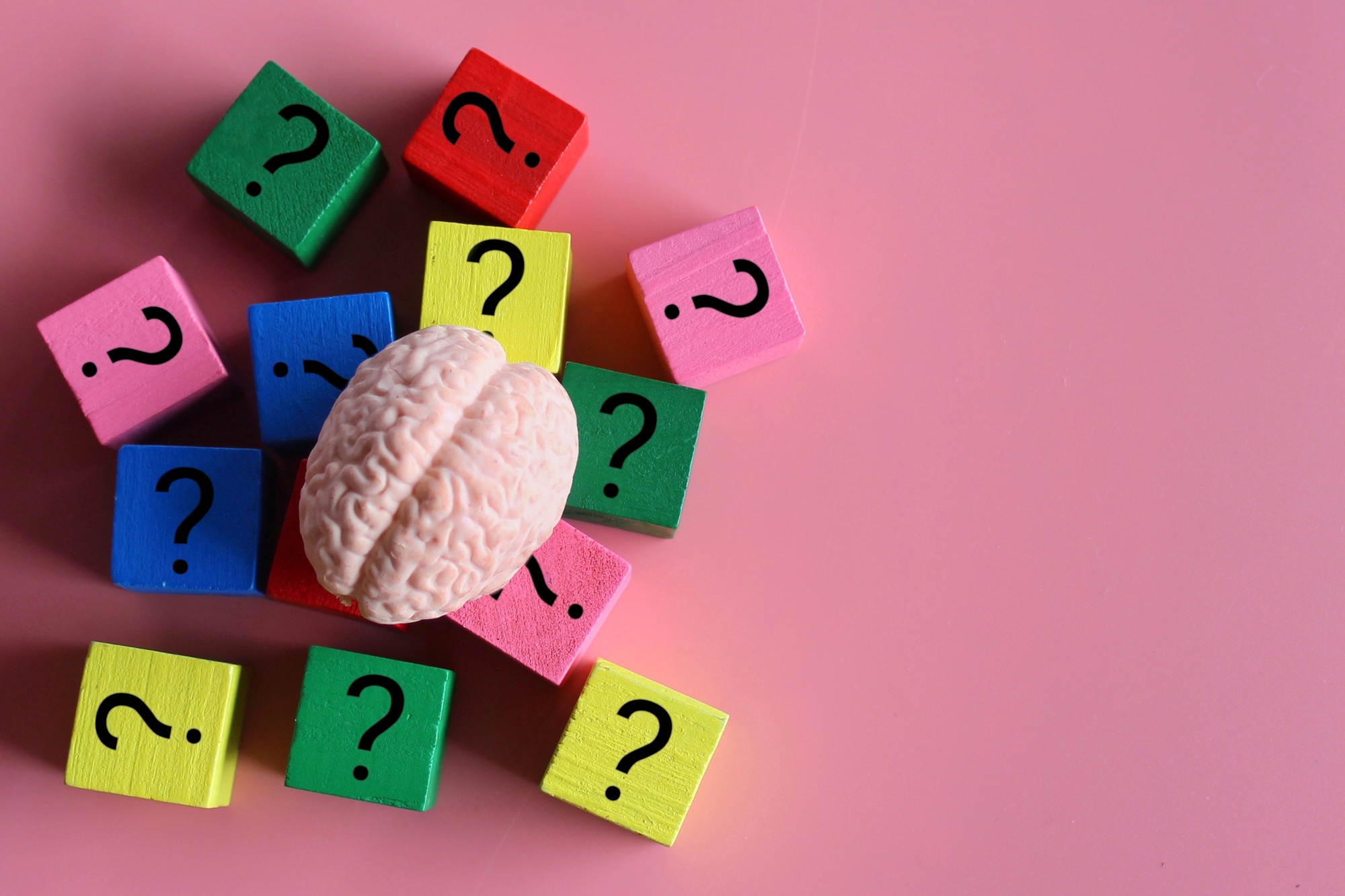 Top view image of brain and wooden cubes with question mark icon.