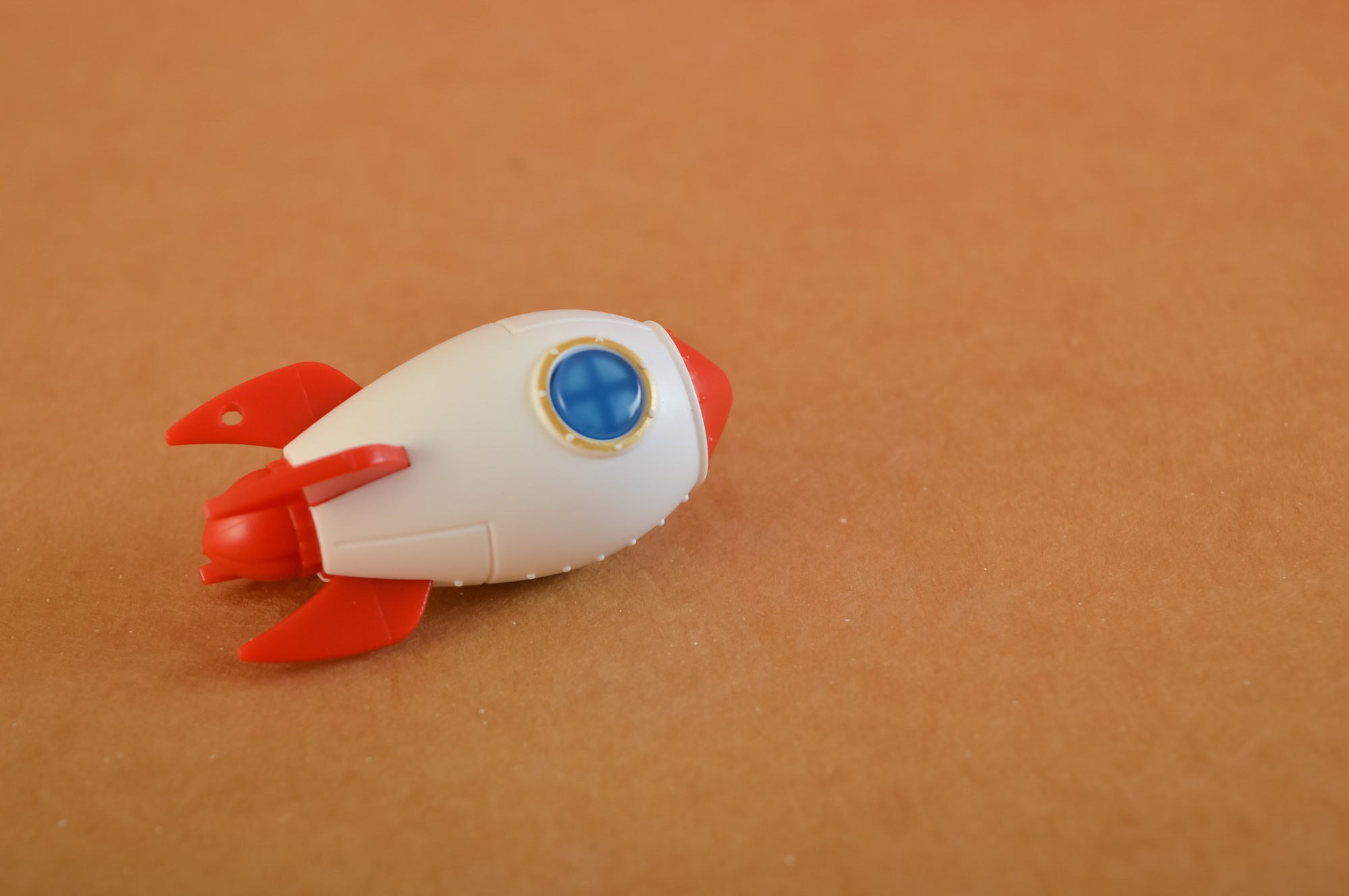 Toy rocket isolated on a brown background. Start up business concept.
