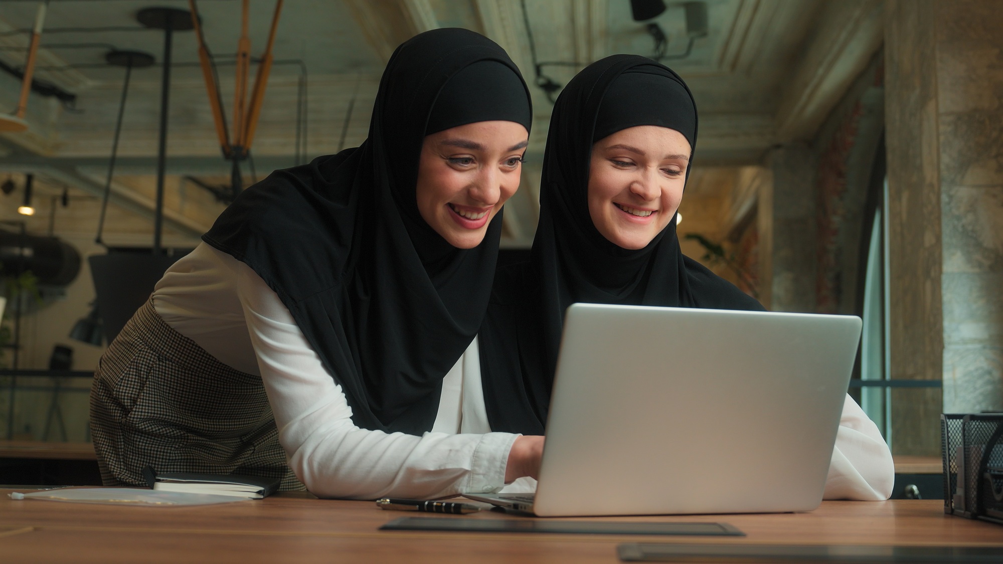 Two Arabian muslim islamic women hijab girls ladies businesswomen advice software laptop consulting