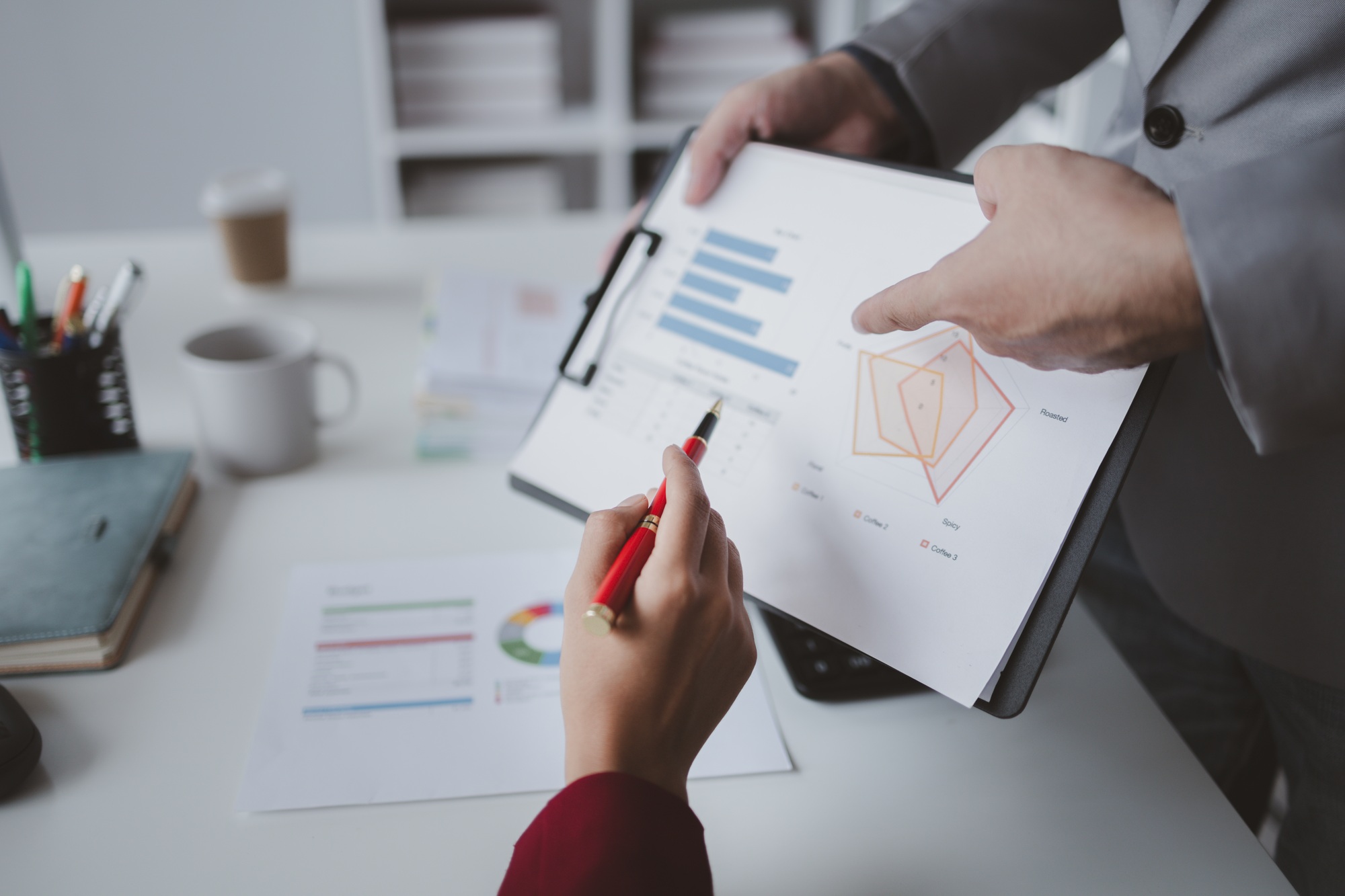 Two businessmen are discussing analyzing company financial papers, operating and marketing planning